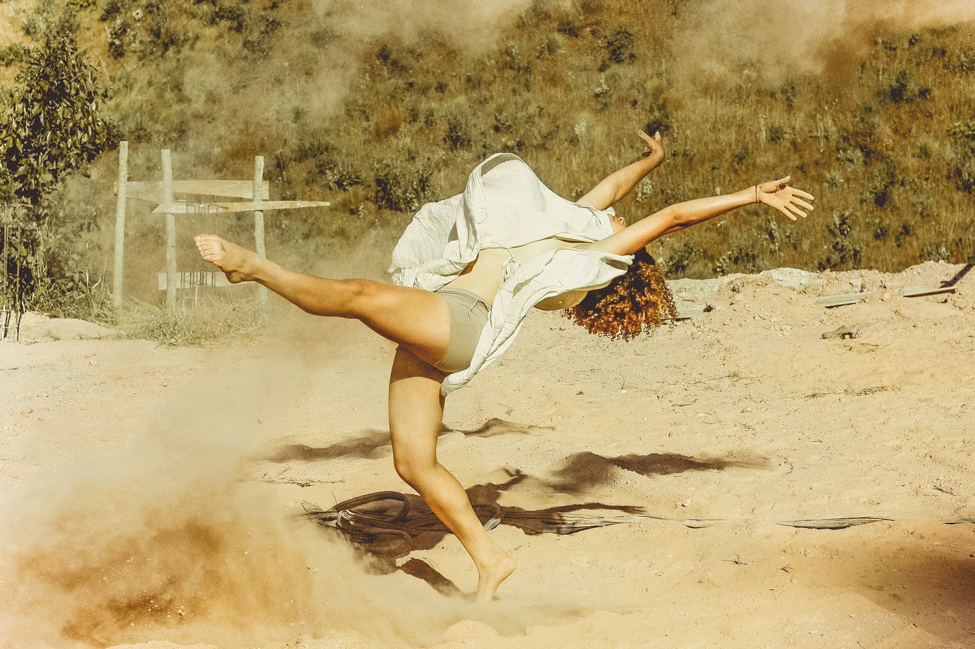 Una donna sta facendo una verticale su una spiaggia sabbiosa.