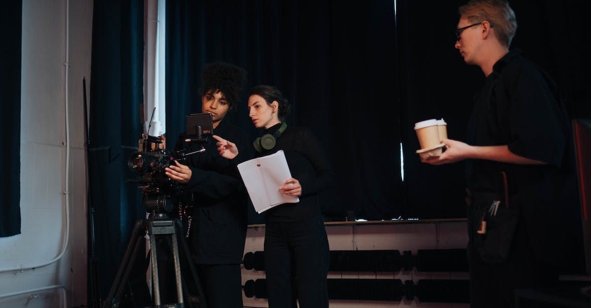 A group of people are standing in front of a camera in a dark room.