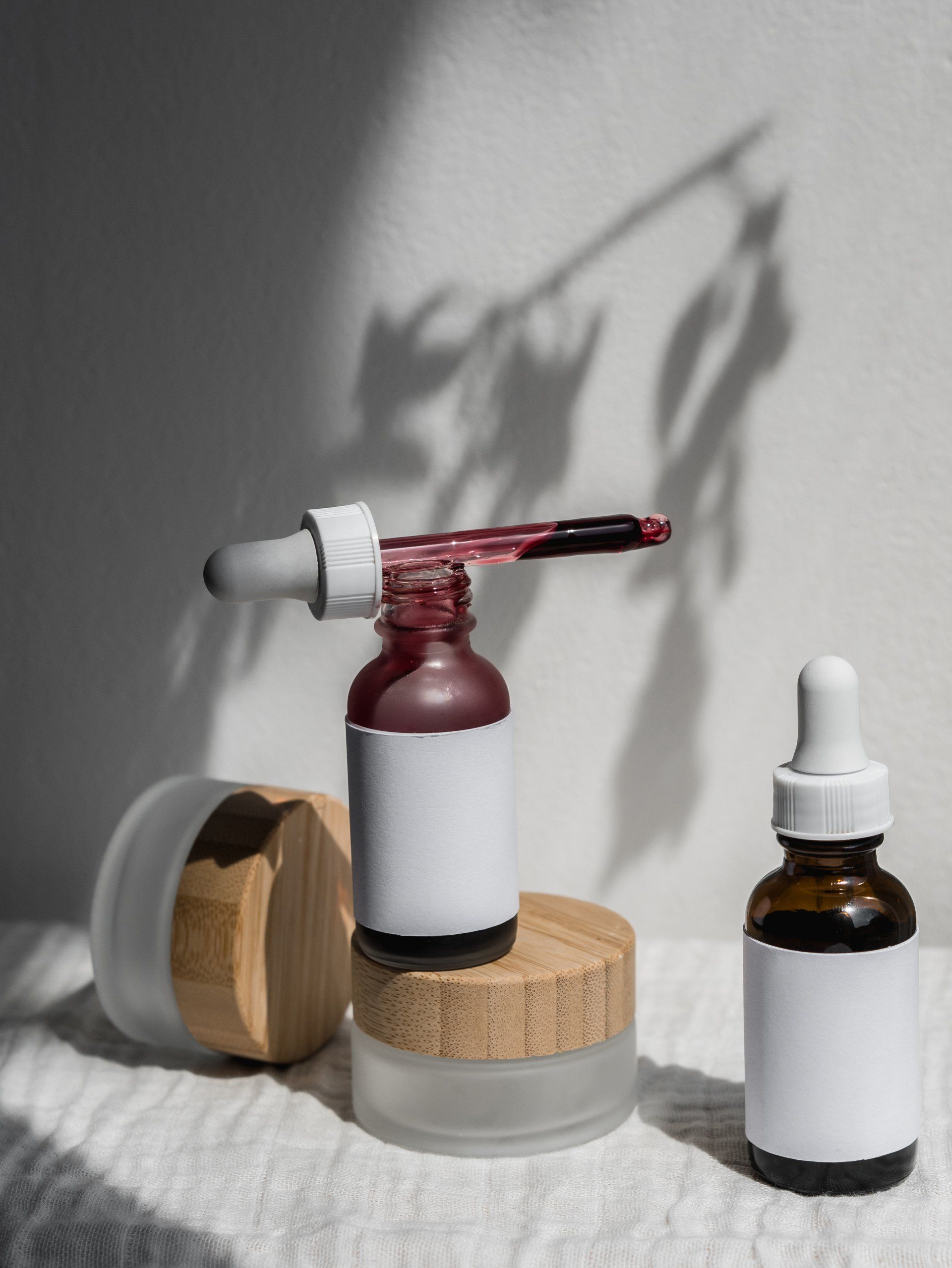 Three bottles of cosmetics are sitting on a table.