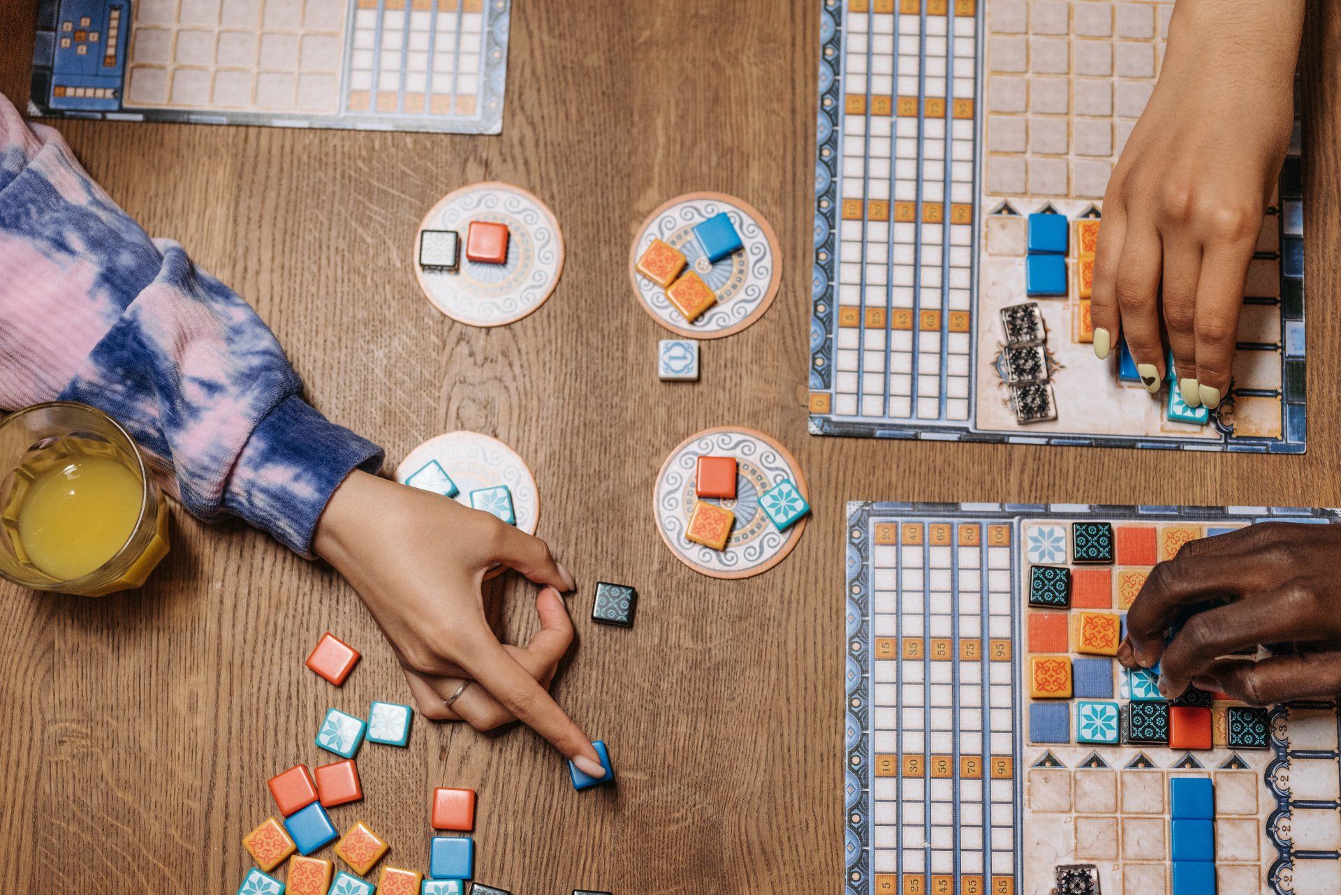 top down view of hands pointing to game pieces on a table