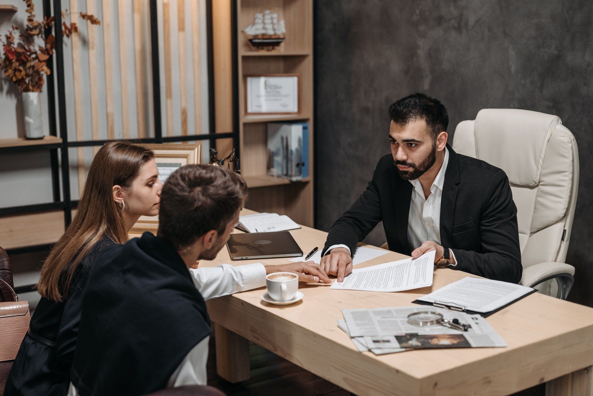 A man and a woman are sitting at a table talking to a lawyer.