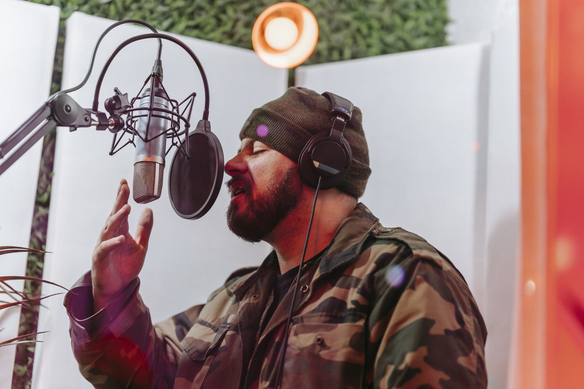 A man in a camouflage jacket is singing into a microphone.