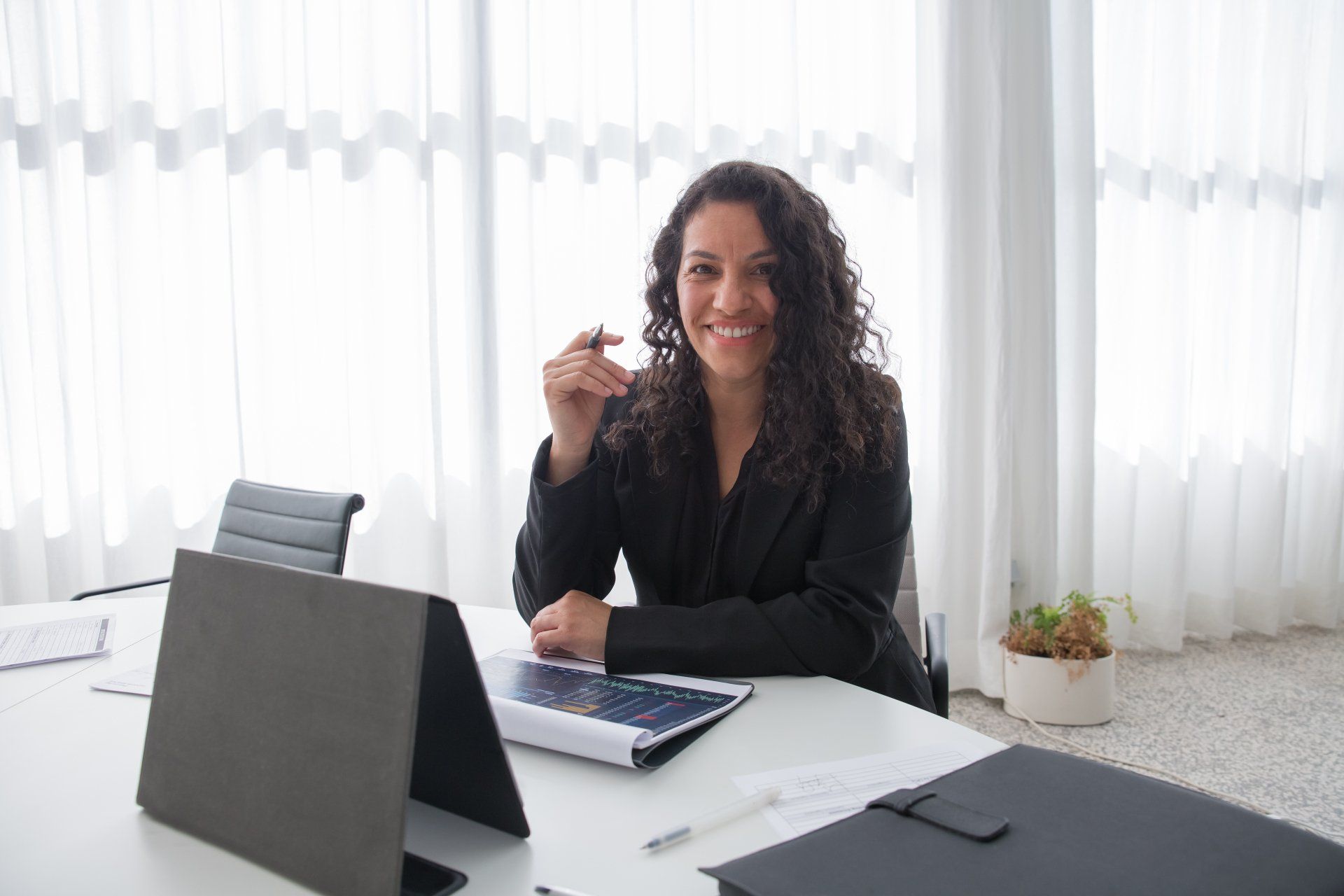 A woman is sitting at a desk in front of a laptop computer.