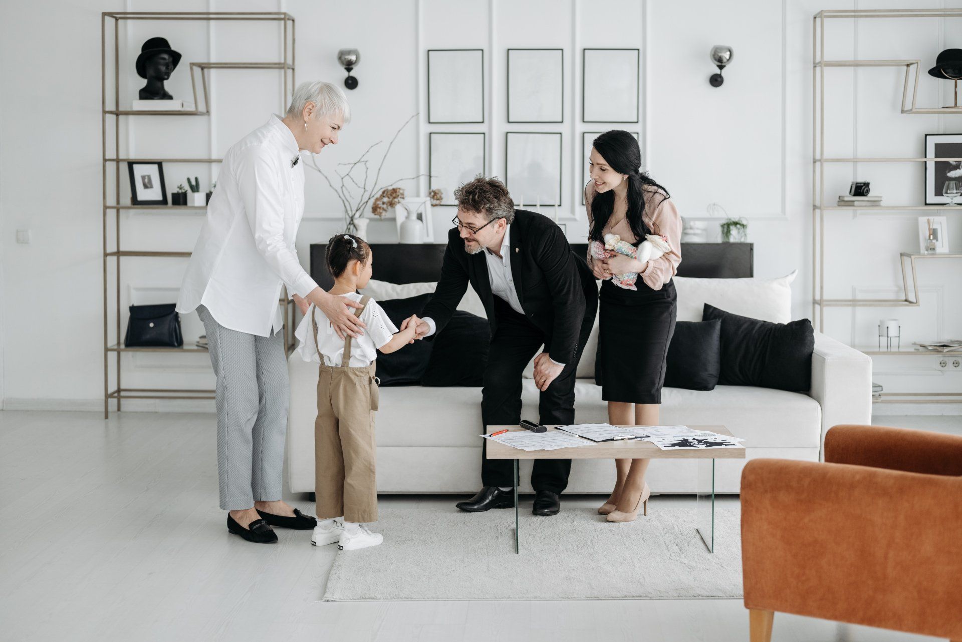 A family is standing in a living room talking to each other.
