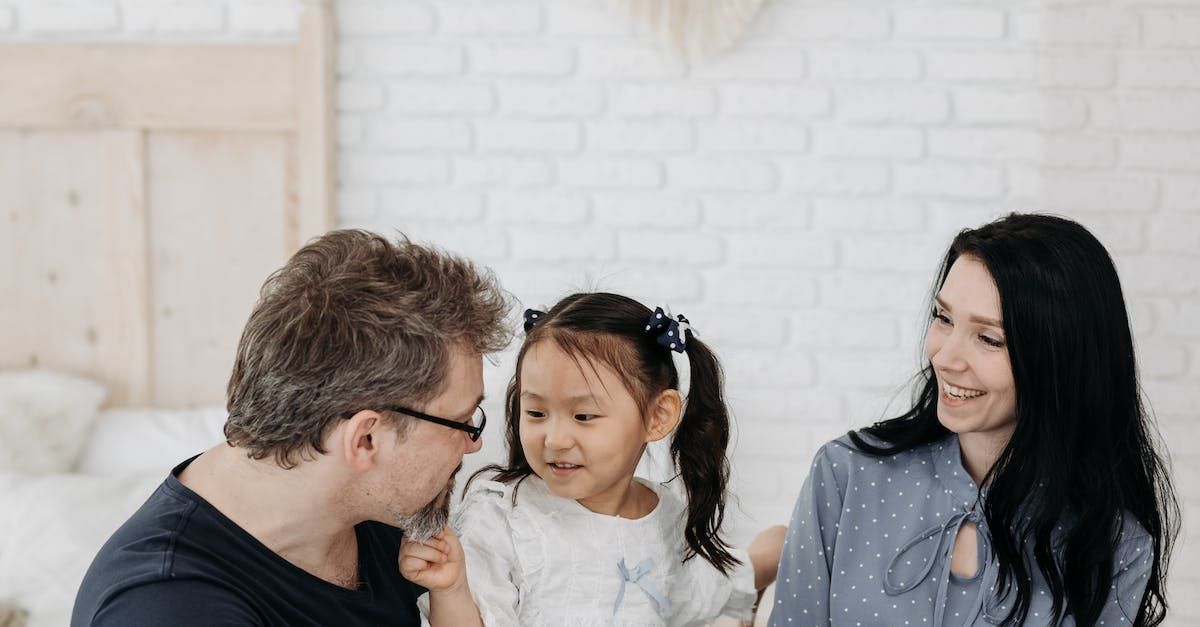 A man and woman are playing with a little girl in a living room.