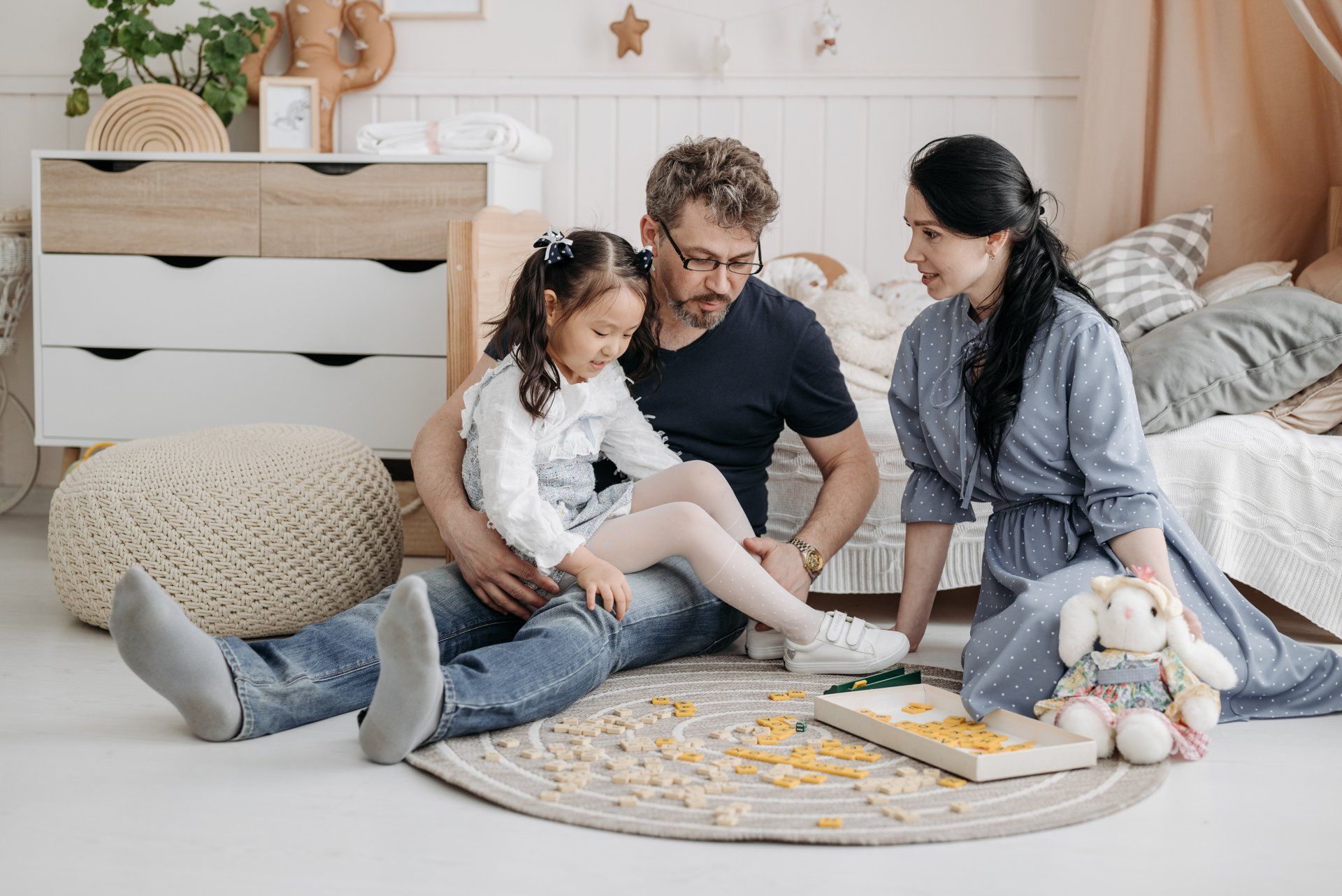 Family playing a game on their child's room floor
