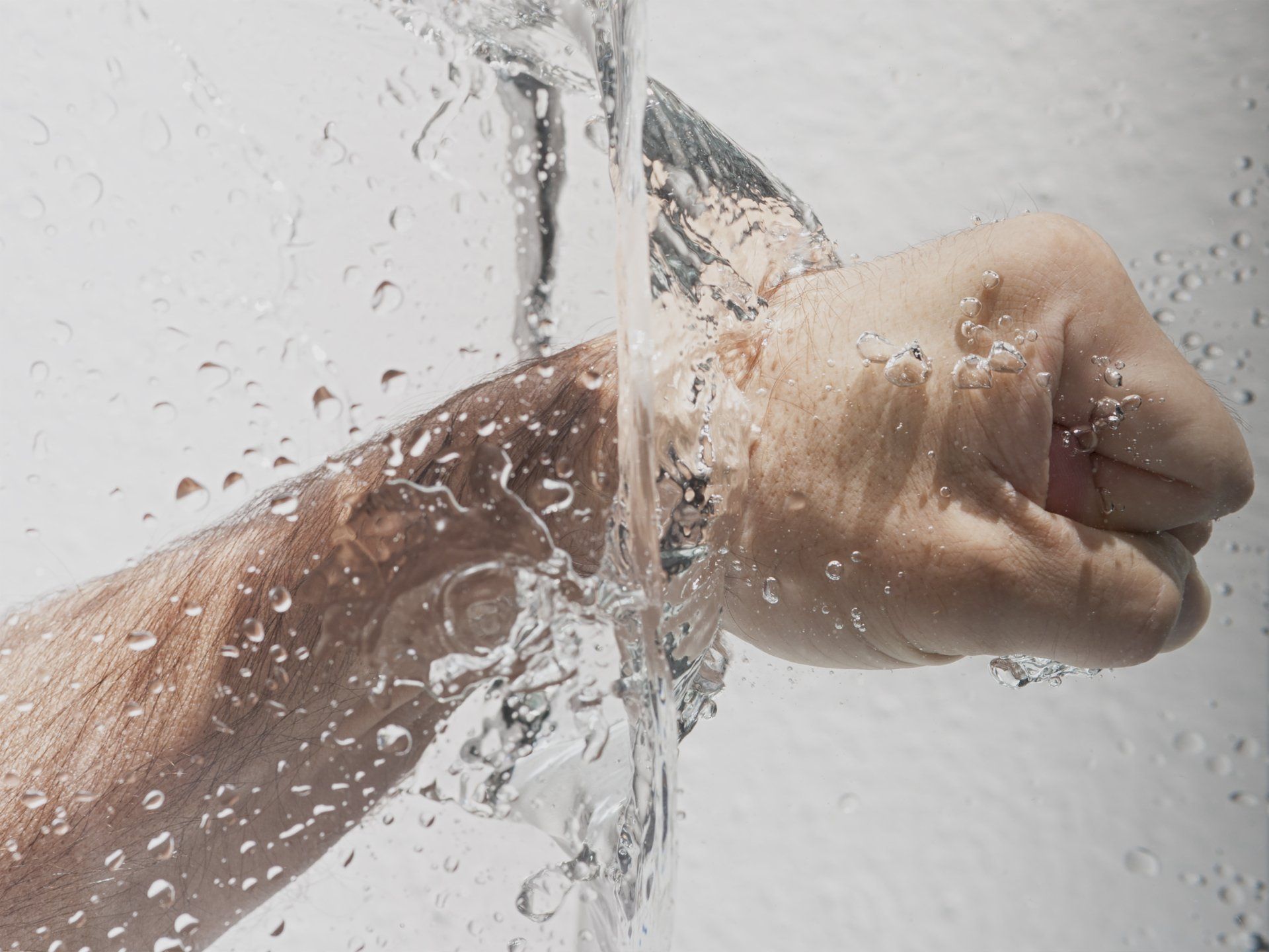 Picture of a mans arm with water running over it
