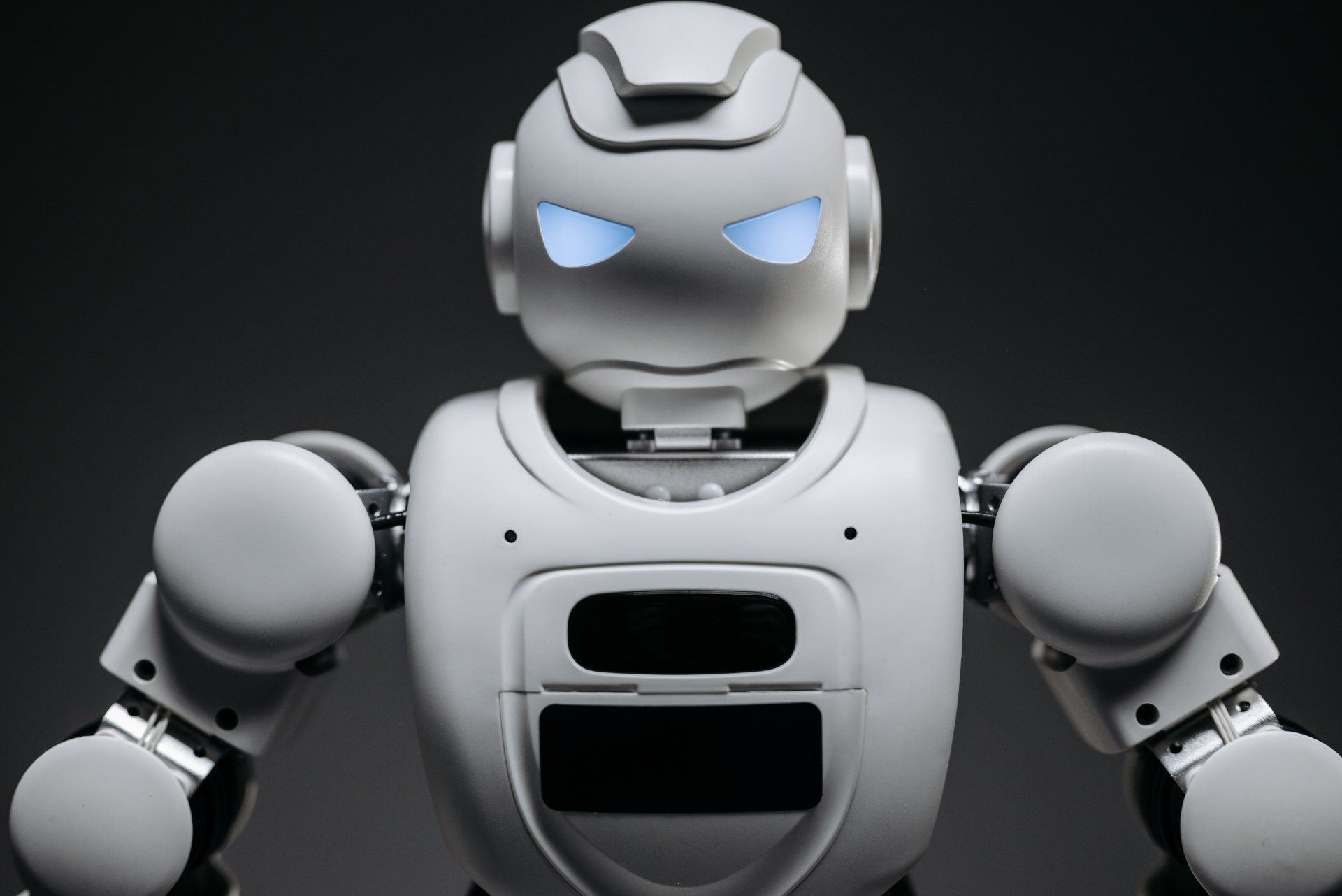 A white robot with blue eyes is looking at the camera