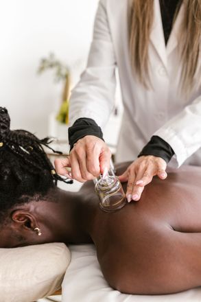 A woman is getting a cupping treatment on her back to increase blood flow and decrease pain in Littleton, CO.