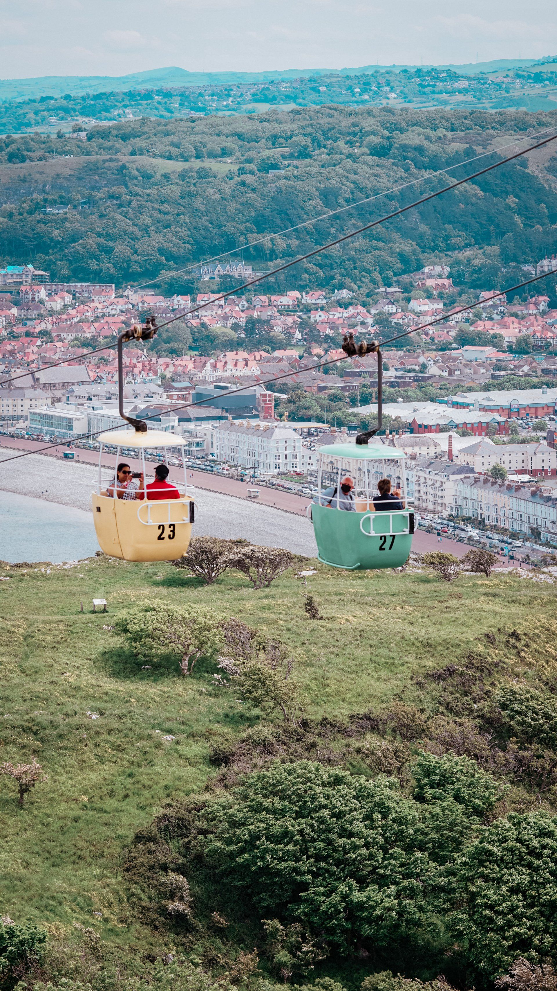 A cable car going up a hill overlooking a city.