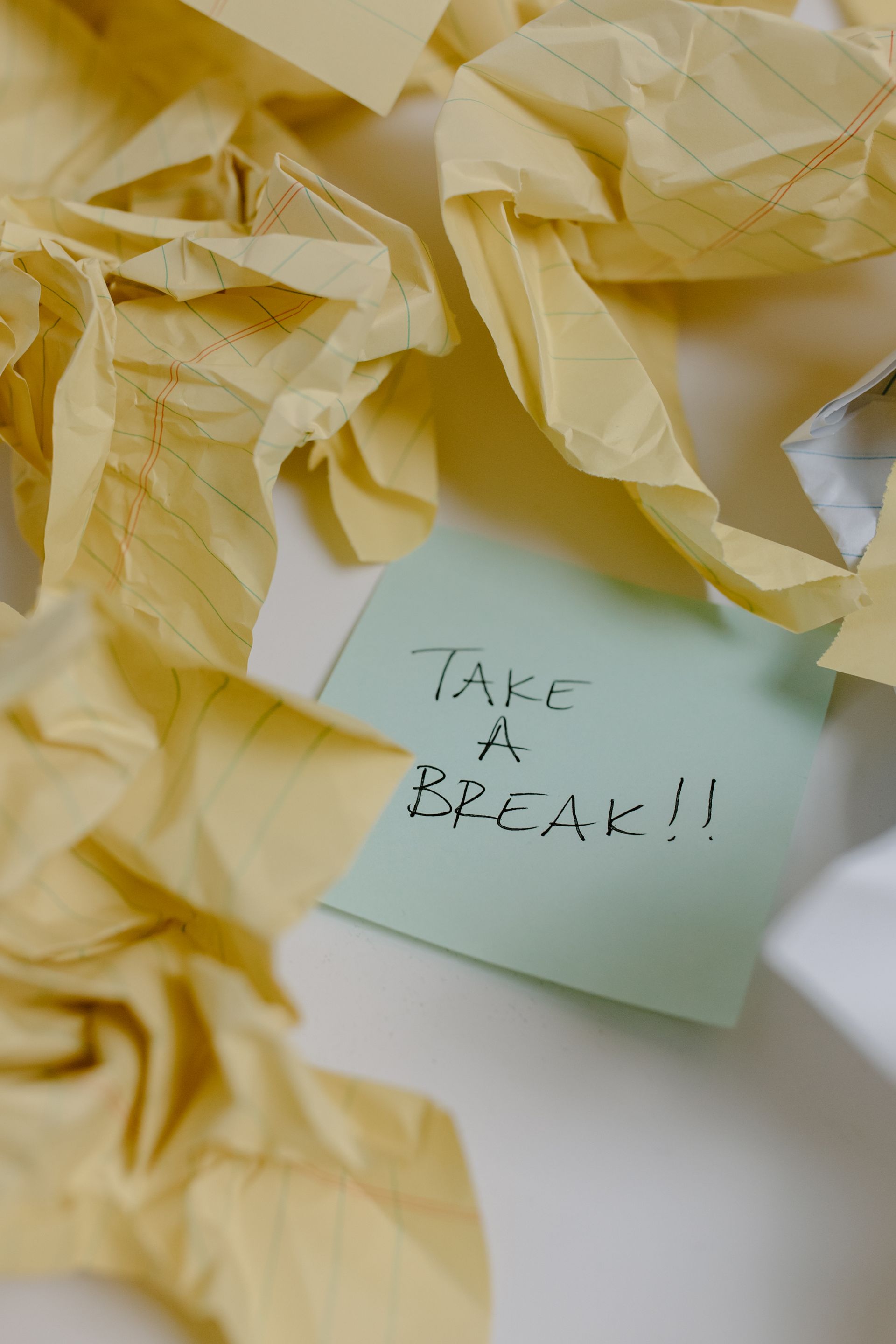 A sticky note that says `` take a break '' is surrounded by crumpled paper.
