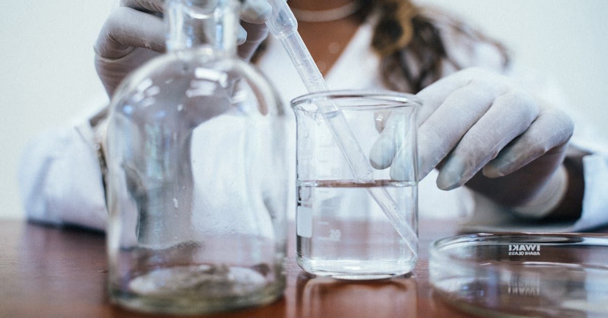 A scientist is pouring liquid into a beaker.
