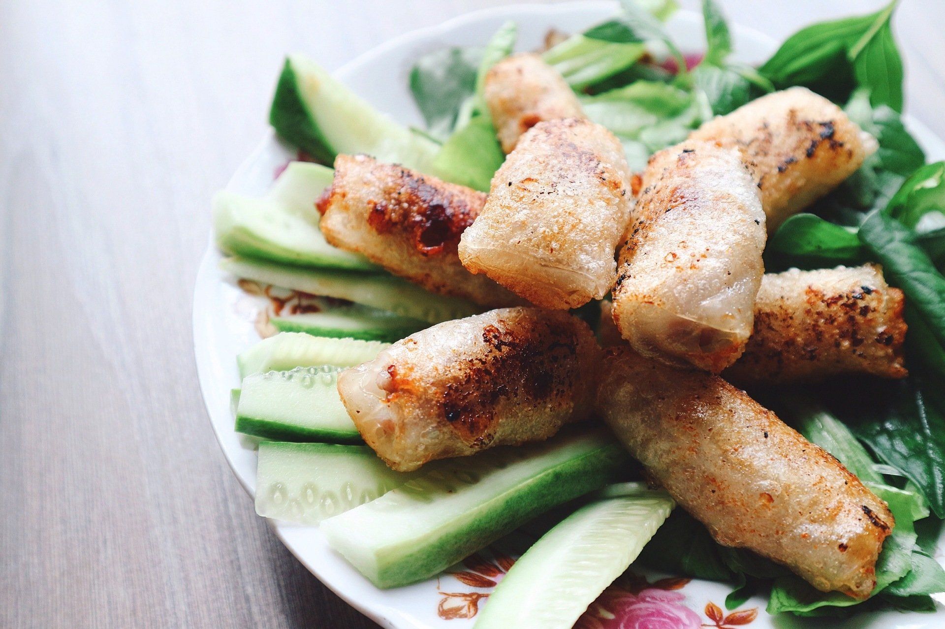 A plate of food with cucumbers and lettuce on a table