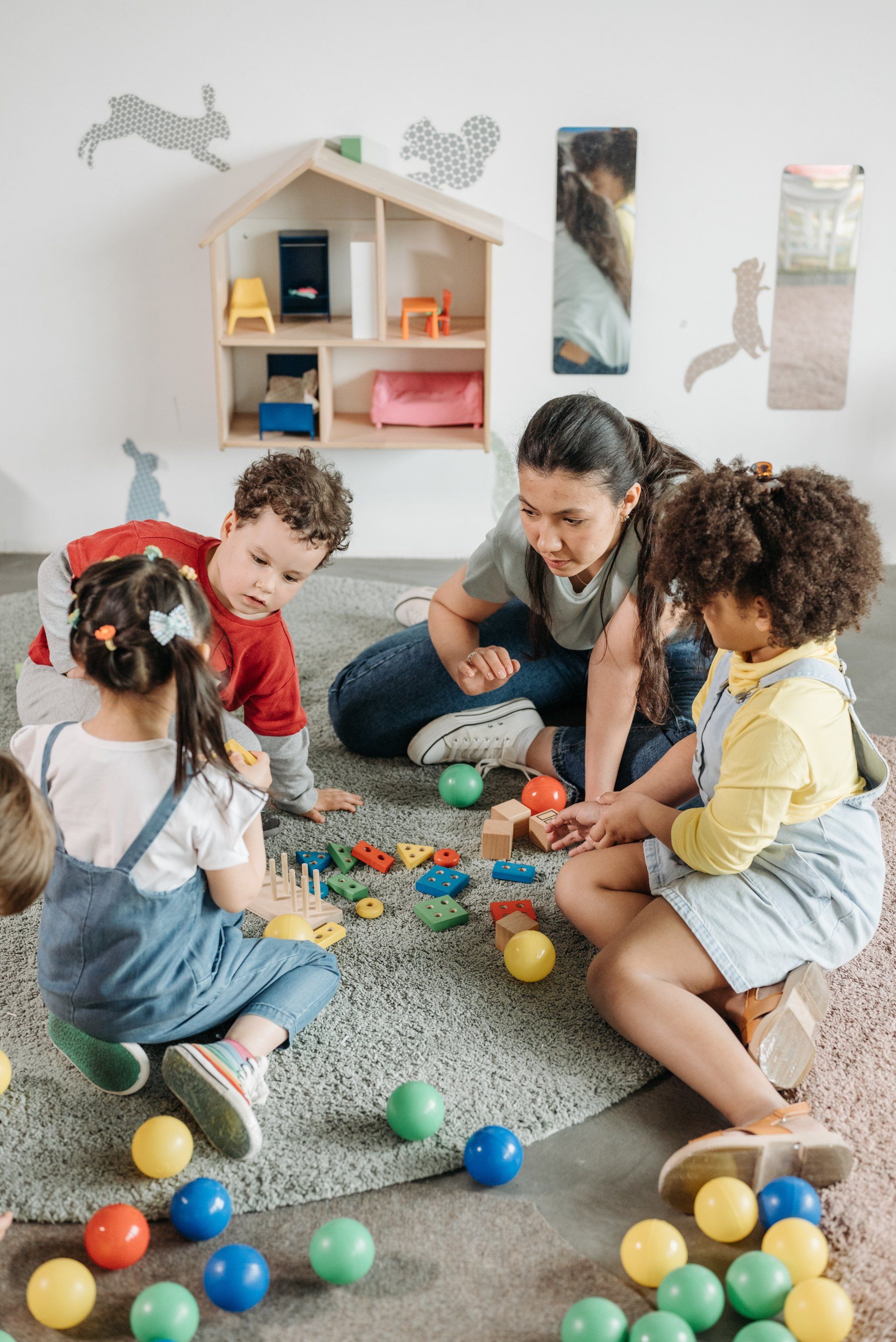 A group of children are sitting on the floor playing with toys.