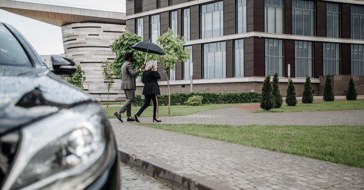 A man and a woman are walking down the street with umbrellas in the rain.