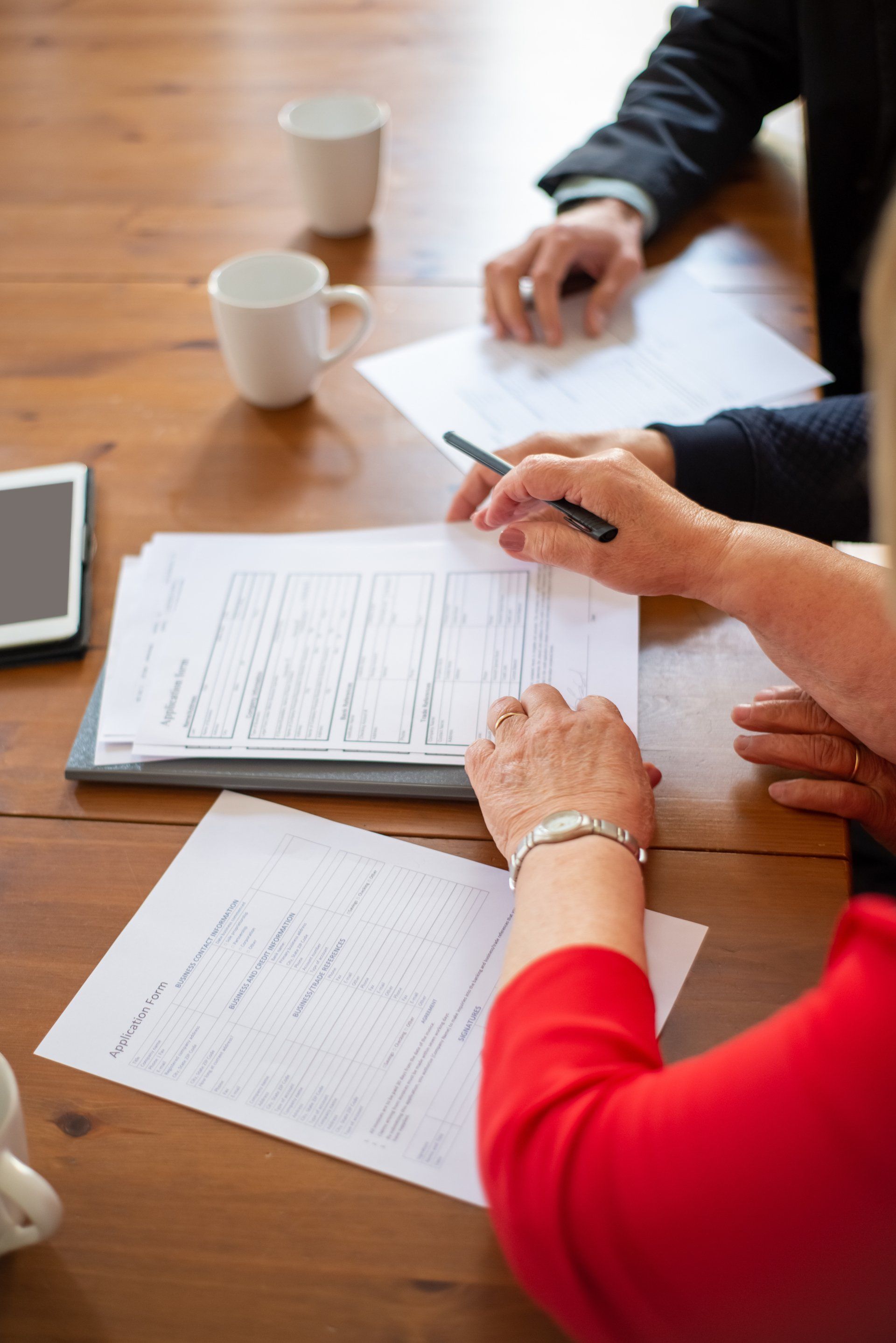 A group of people are sitting at a table looking at papers.