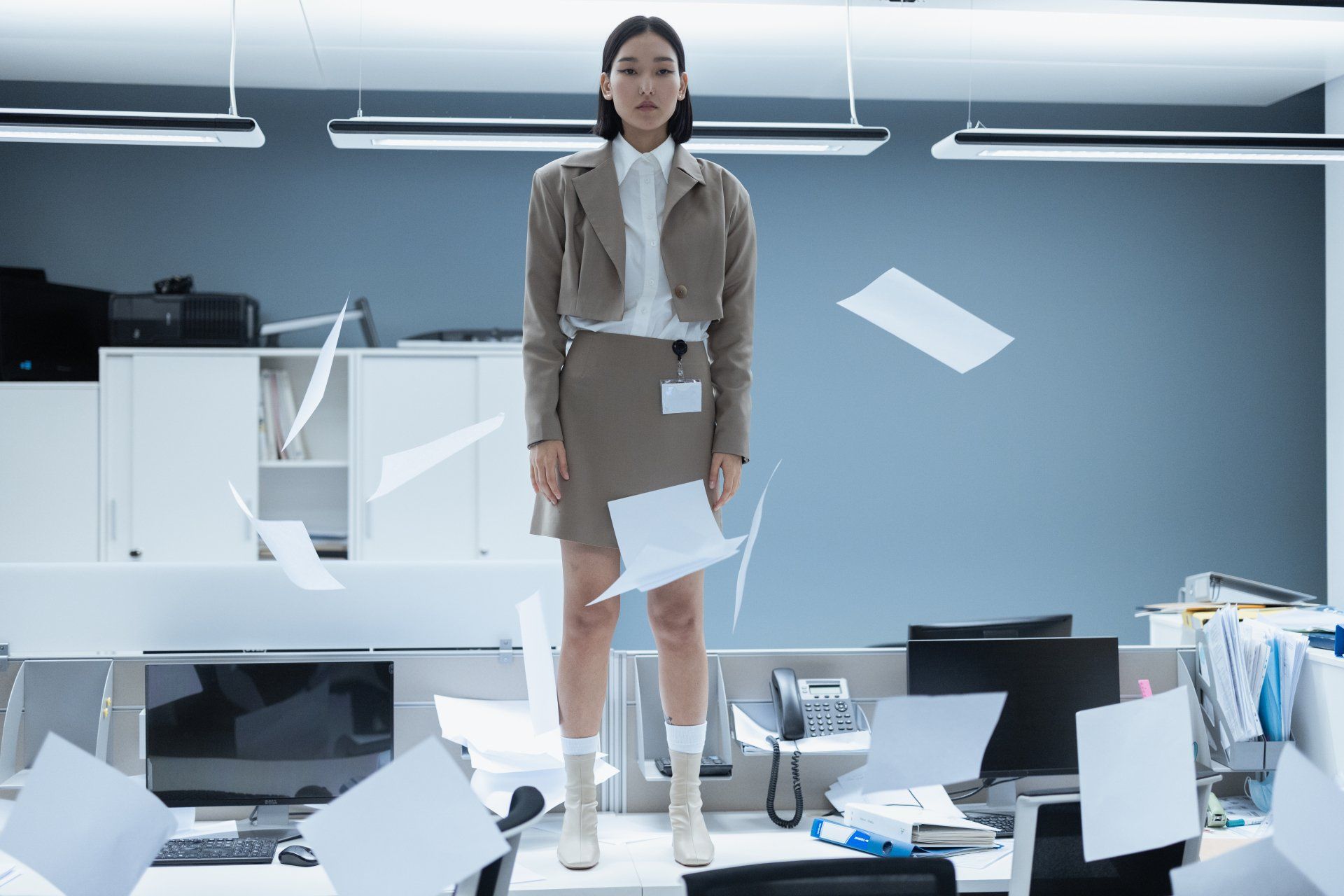 Woman standing on a desk with paperwork