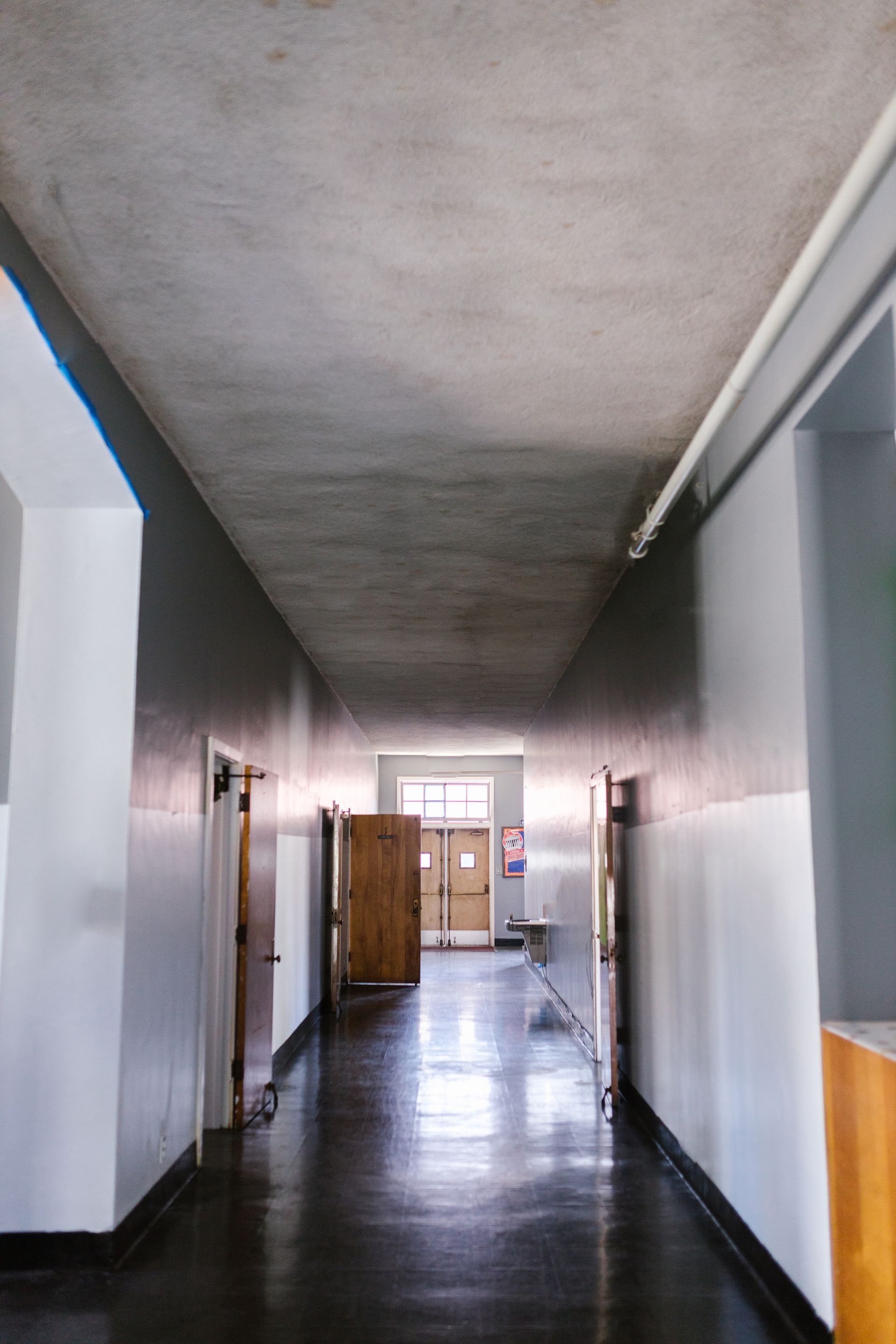 A long hallway with white walls and black floors