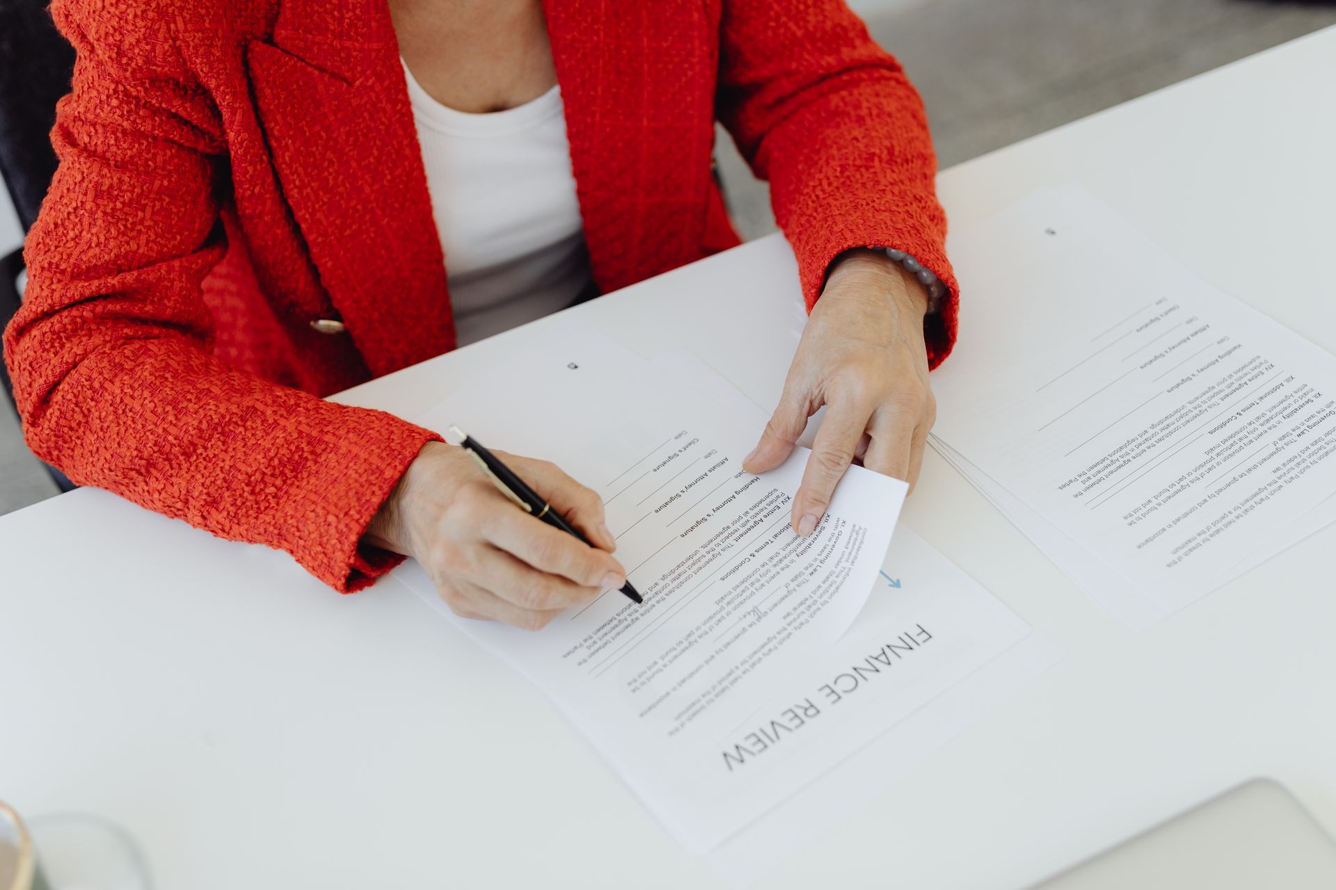 a woman in a red jacket is signing a form