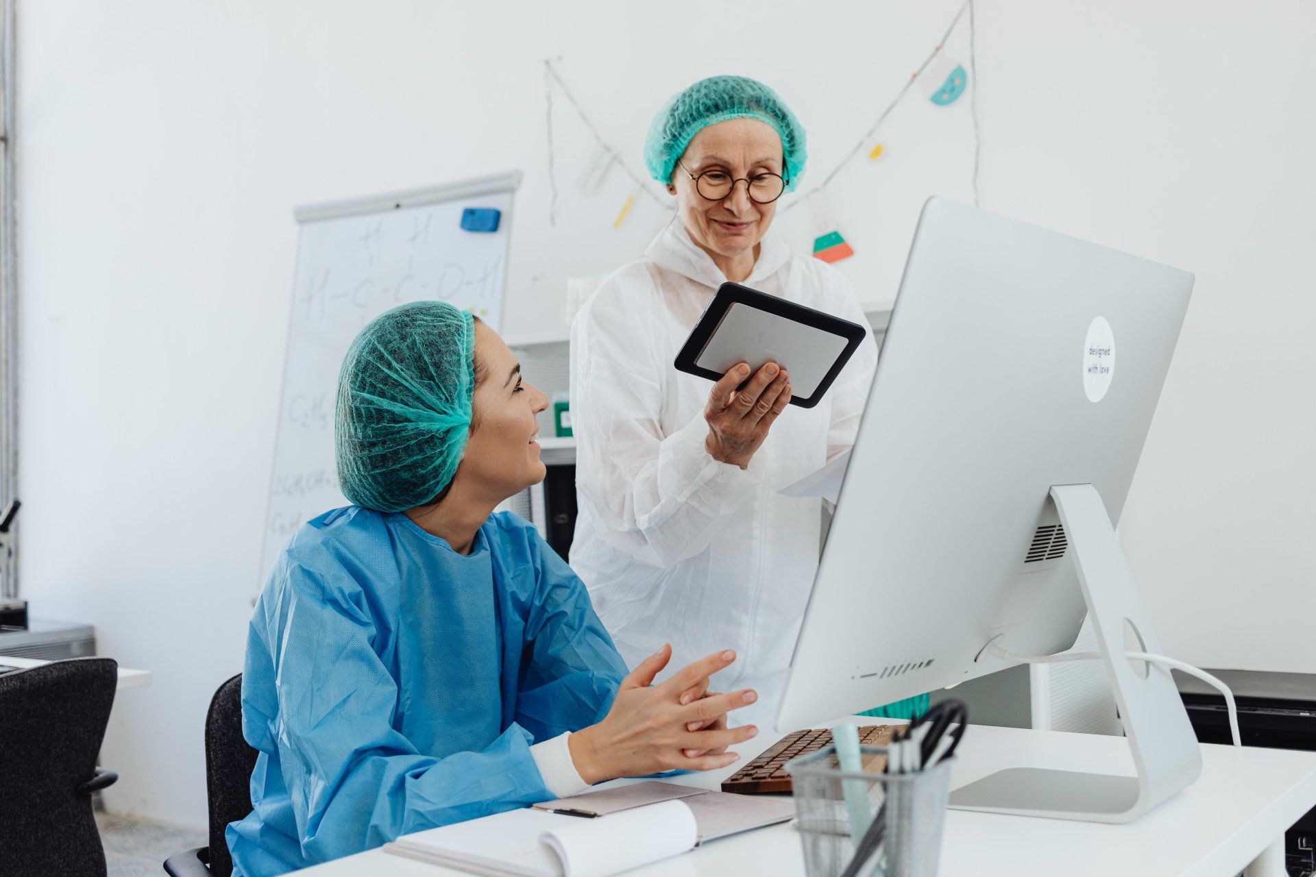 Two female doctors are looking at a computer screen.