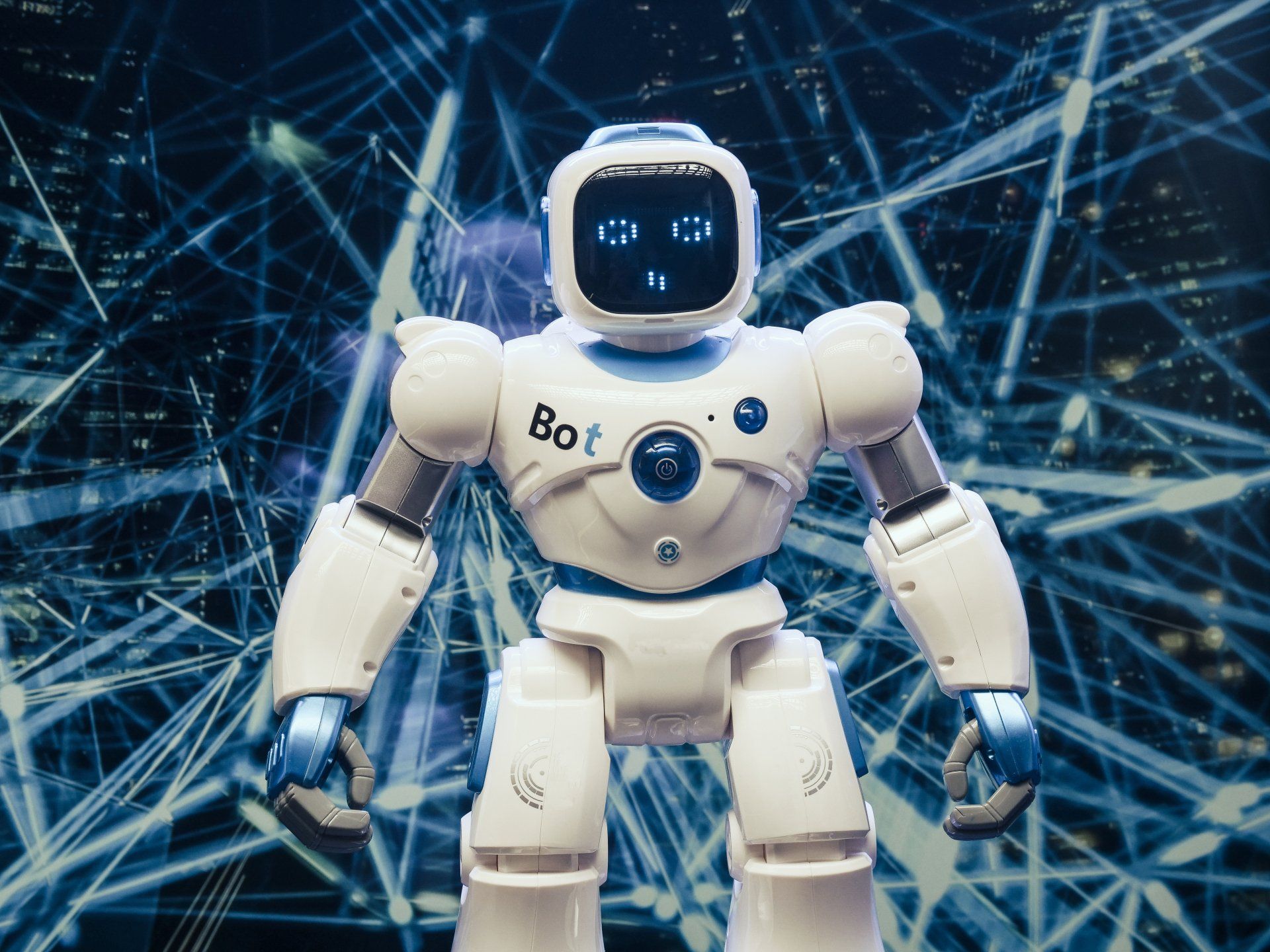 A white robot with blue eyes is standing in front of a blue background.
