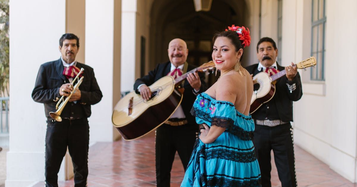 A woman in a blue dress is standing in front of a mariachi band.