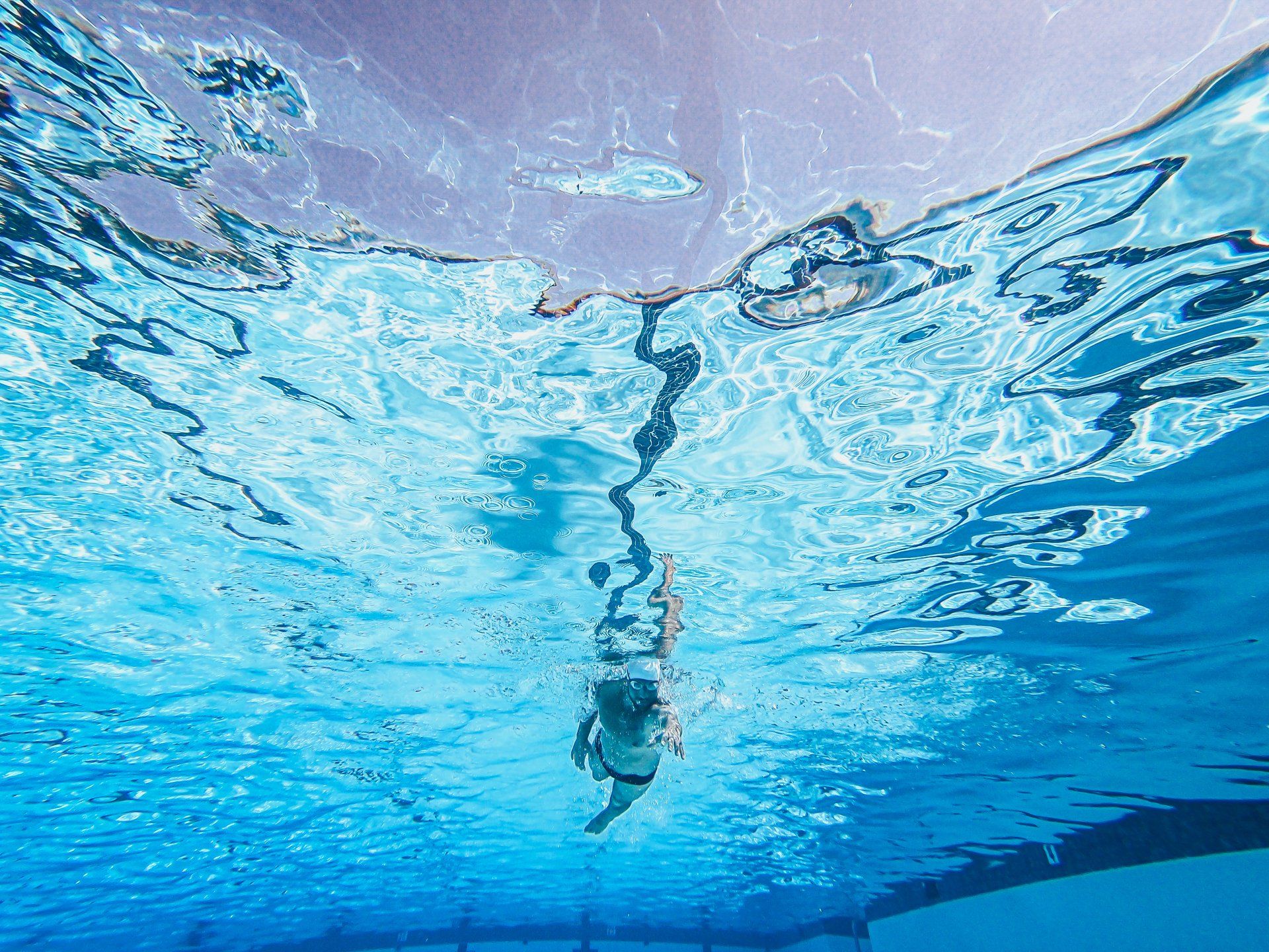 a woman is swimming underwater in a pool
