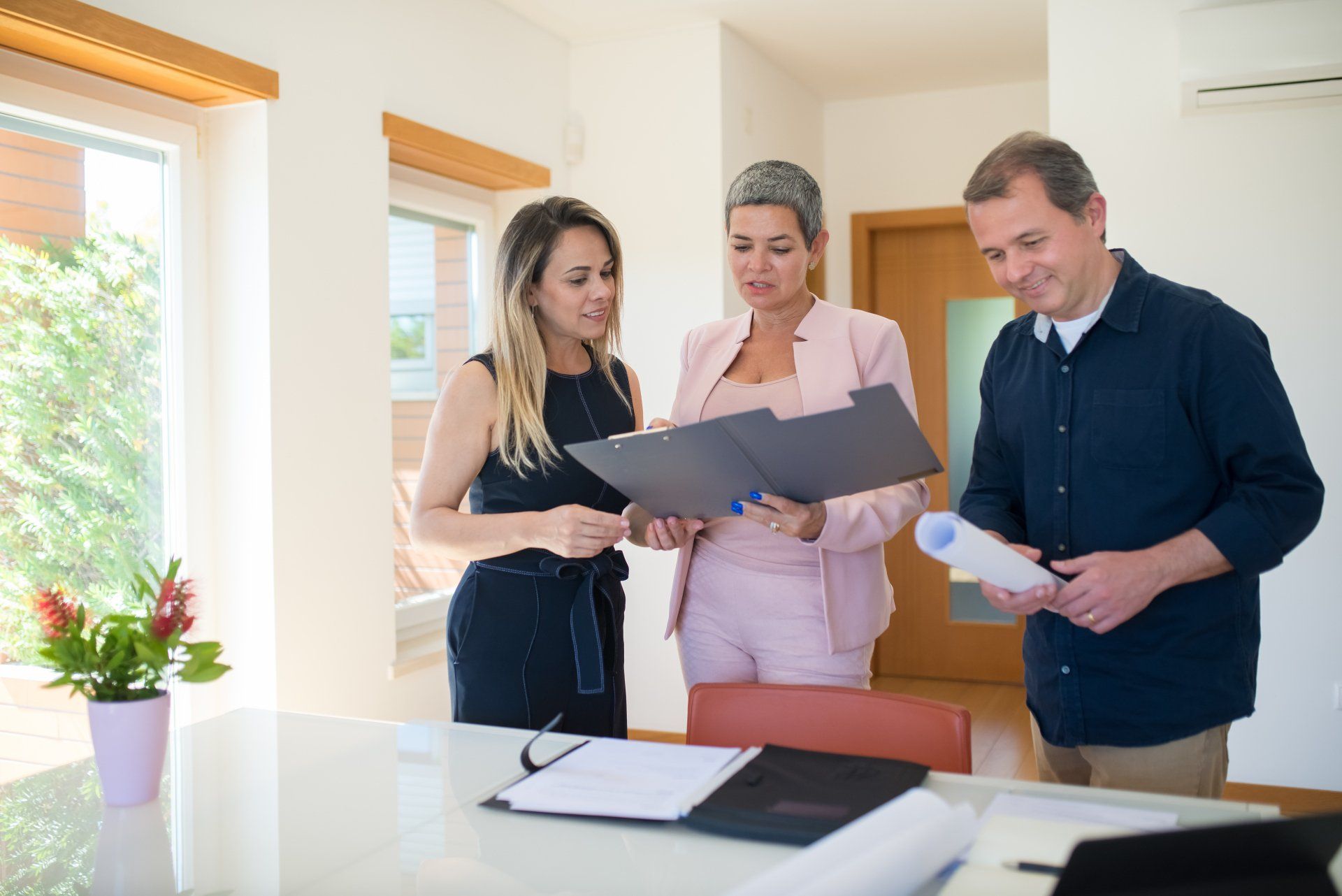 A group of people are standing around a table looking at papers.