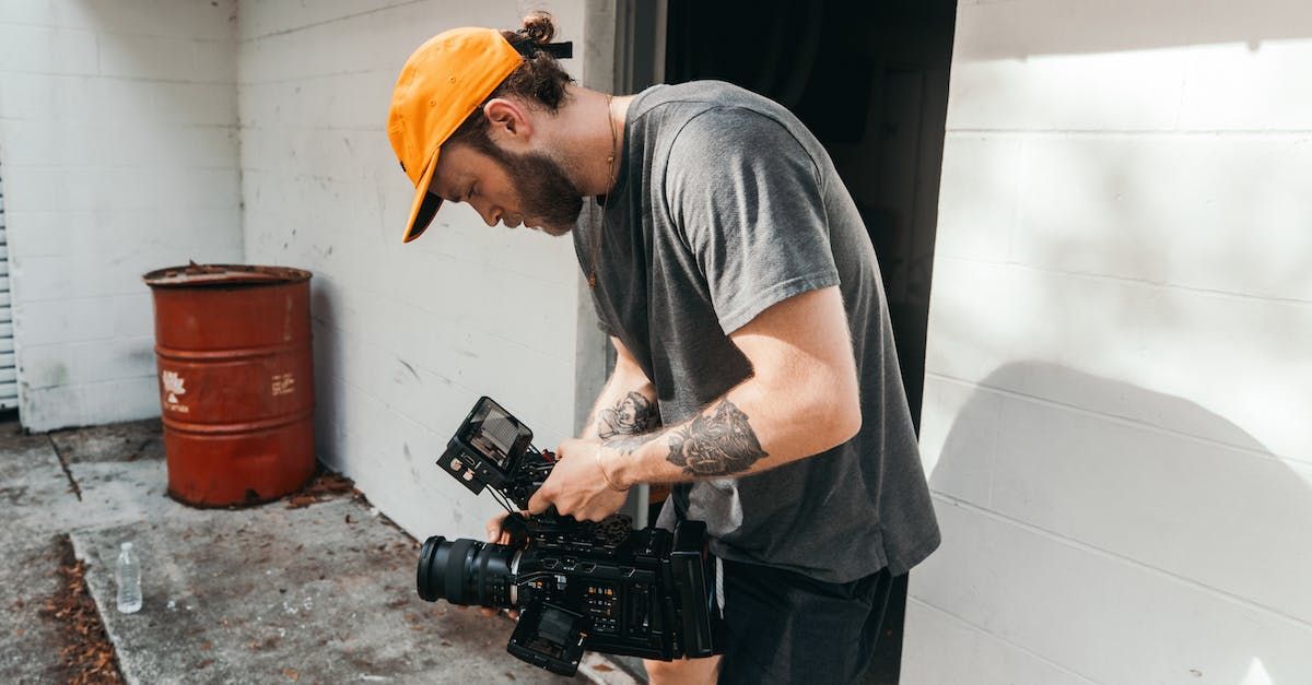 A man in an orange hat is holding a camera.