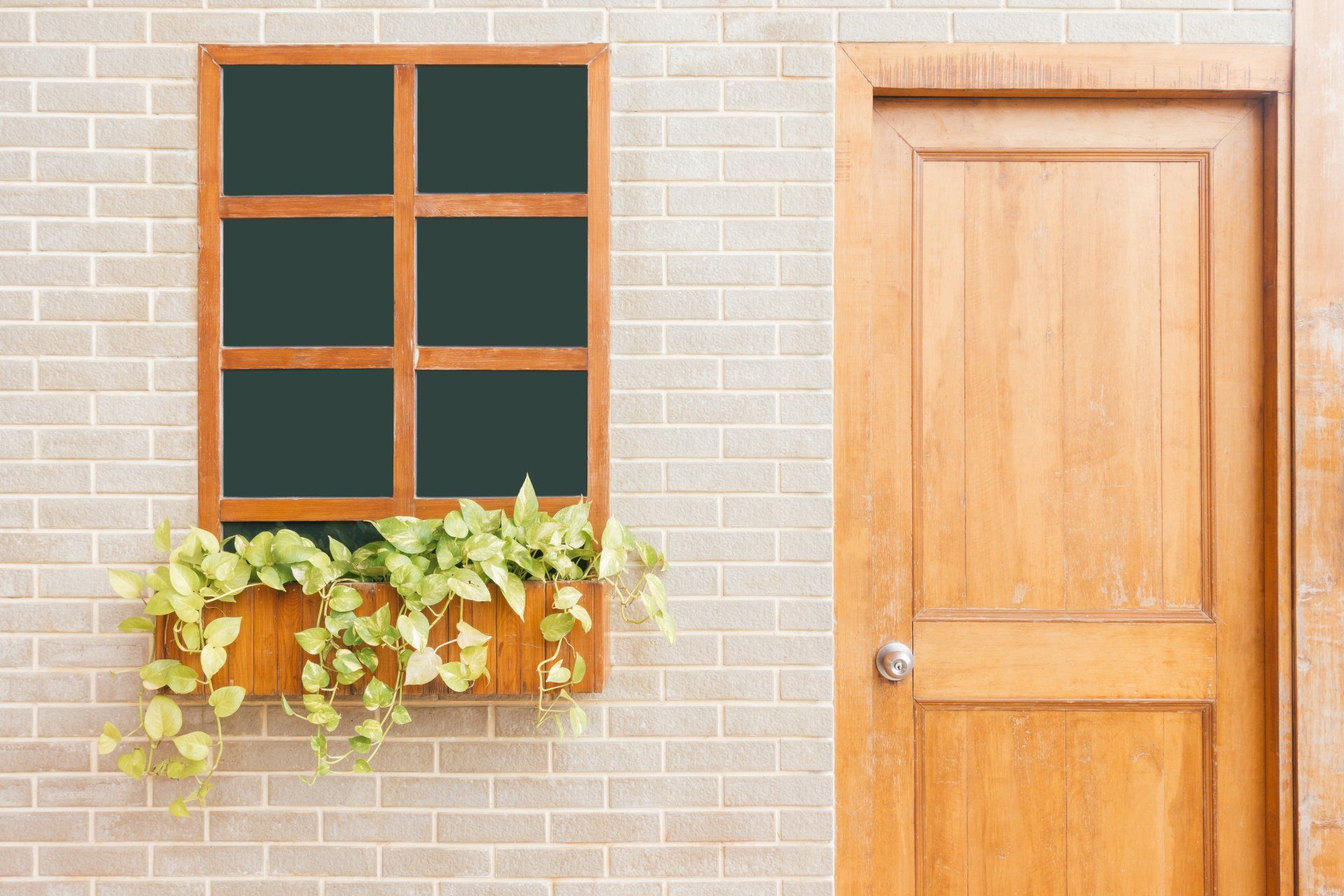 a brick wall with a window and a wooden door .