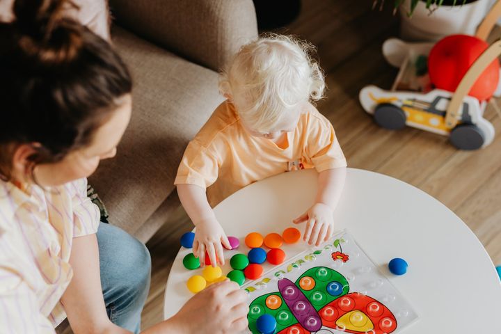 A child playing a game with their mother.