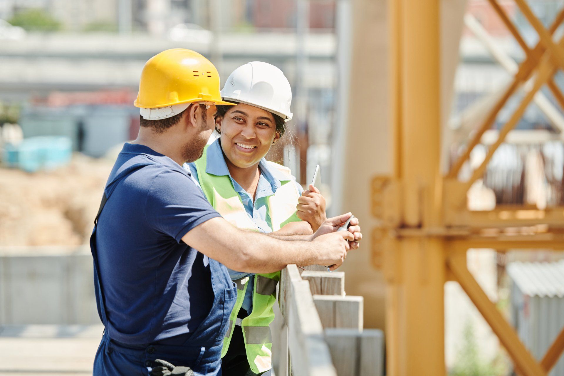 A man and a woman are talking to each other on a construction site.