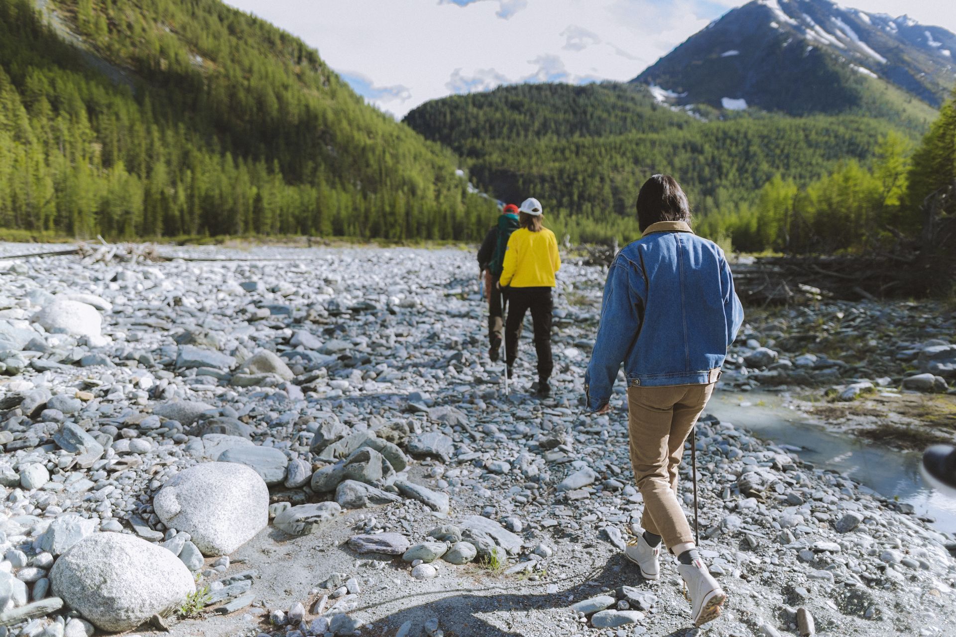 Group of people walking along a rocky river