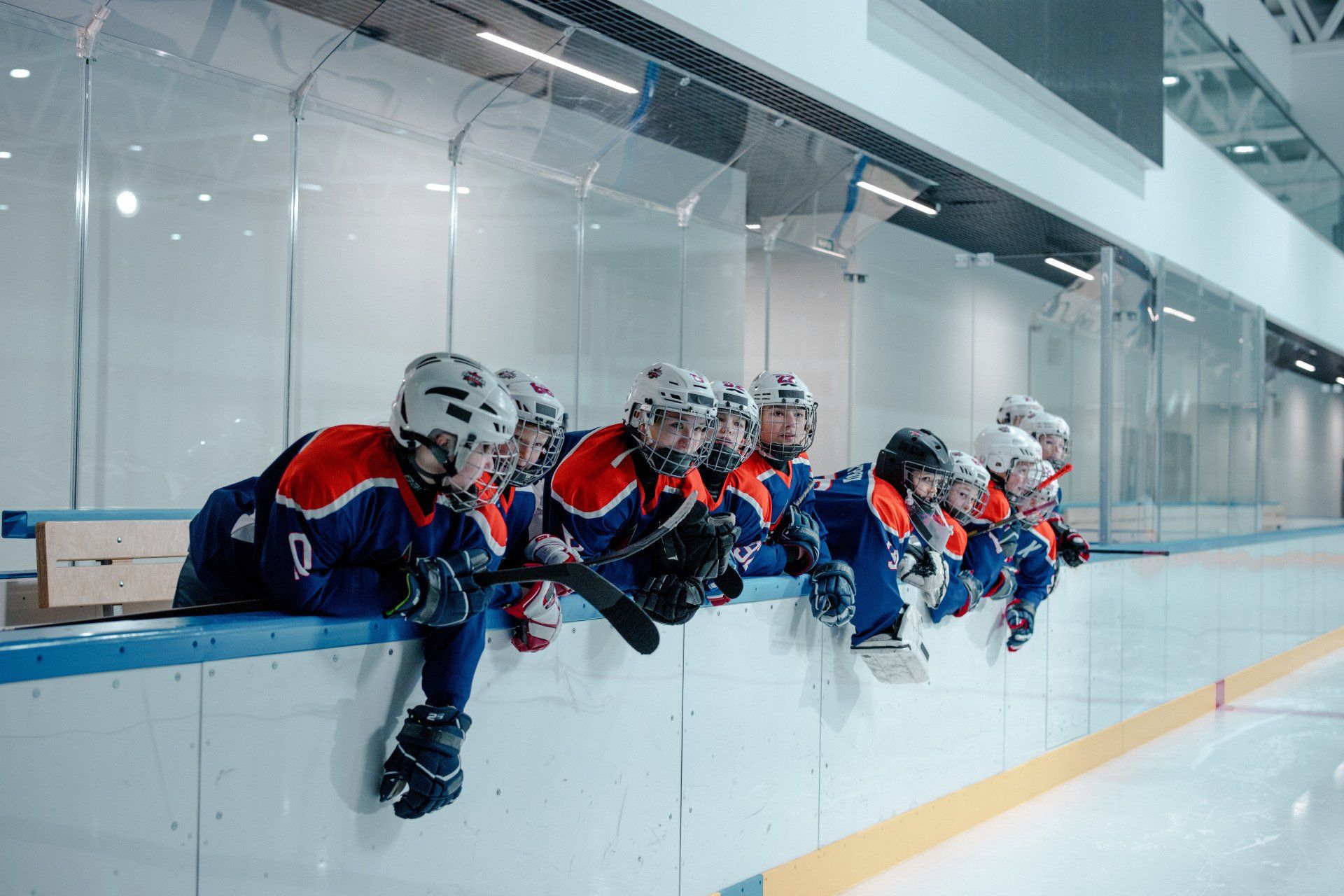 A group of young hockey players are sitting on the ice.