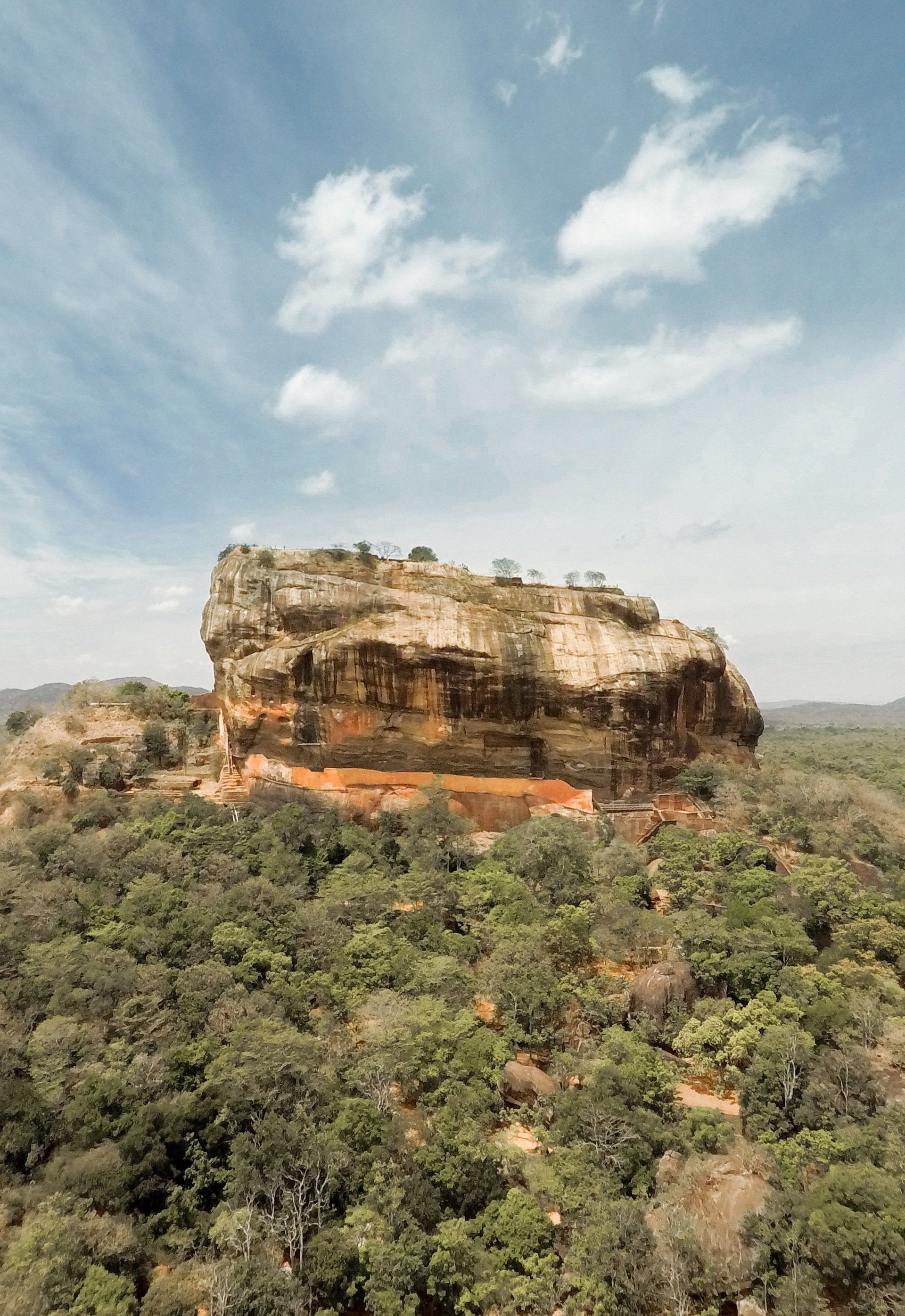 An aerial view of a large rock formation surrounded by trees.