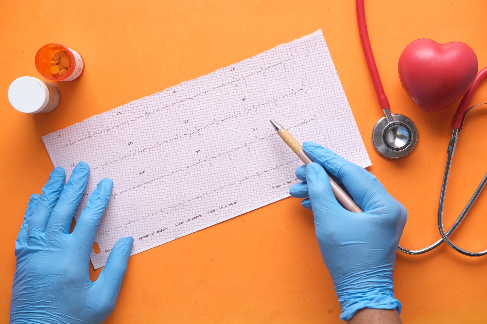 A person wearing blue gloves is writing on a piece of paper with a pencil.