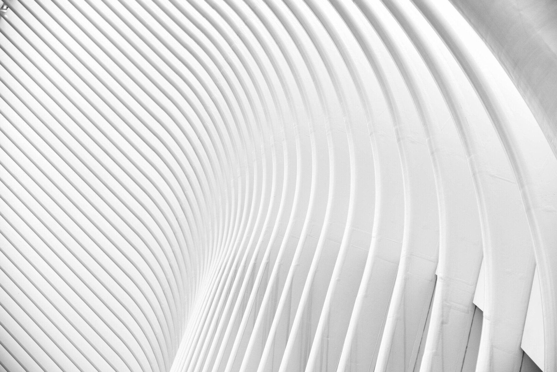 A black and white photo of a white building with a spiral pattern.