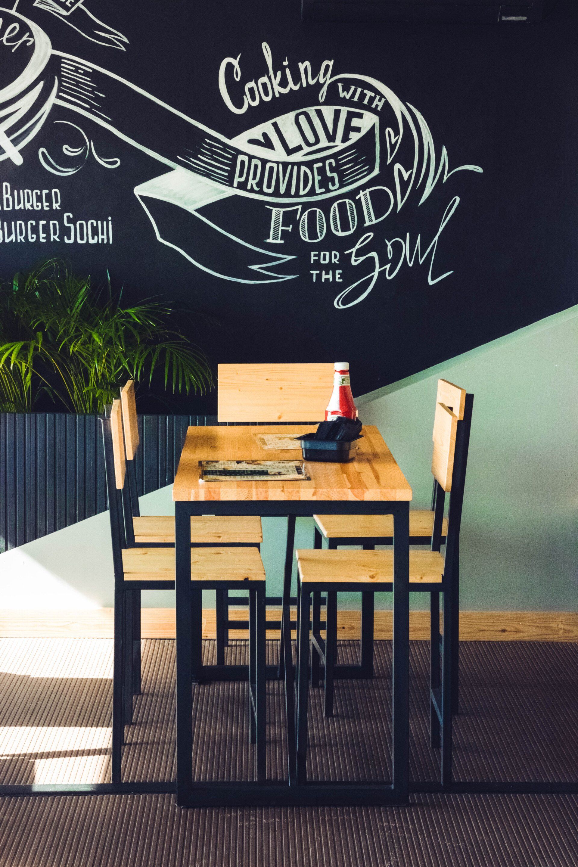 a restaurant table with menus and a bottle of ketchup