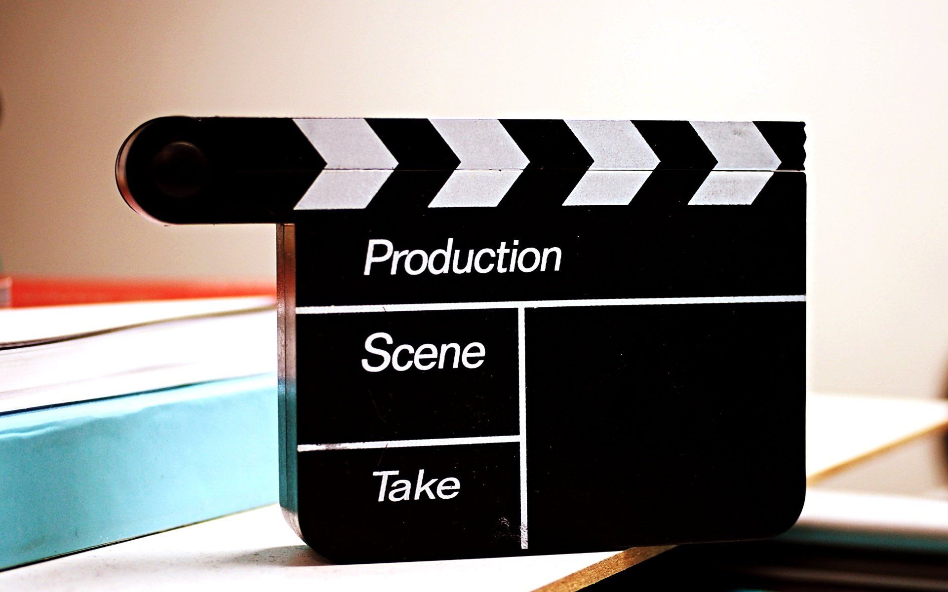 A clapper board with the words production scene and take on it
