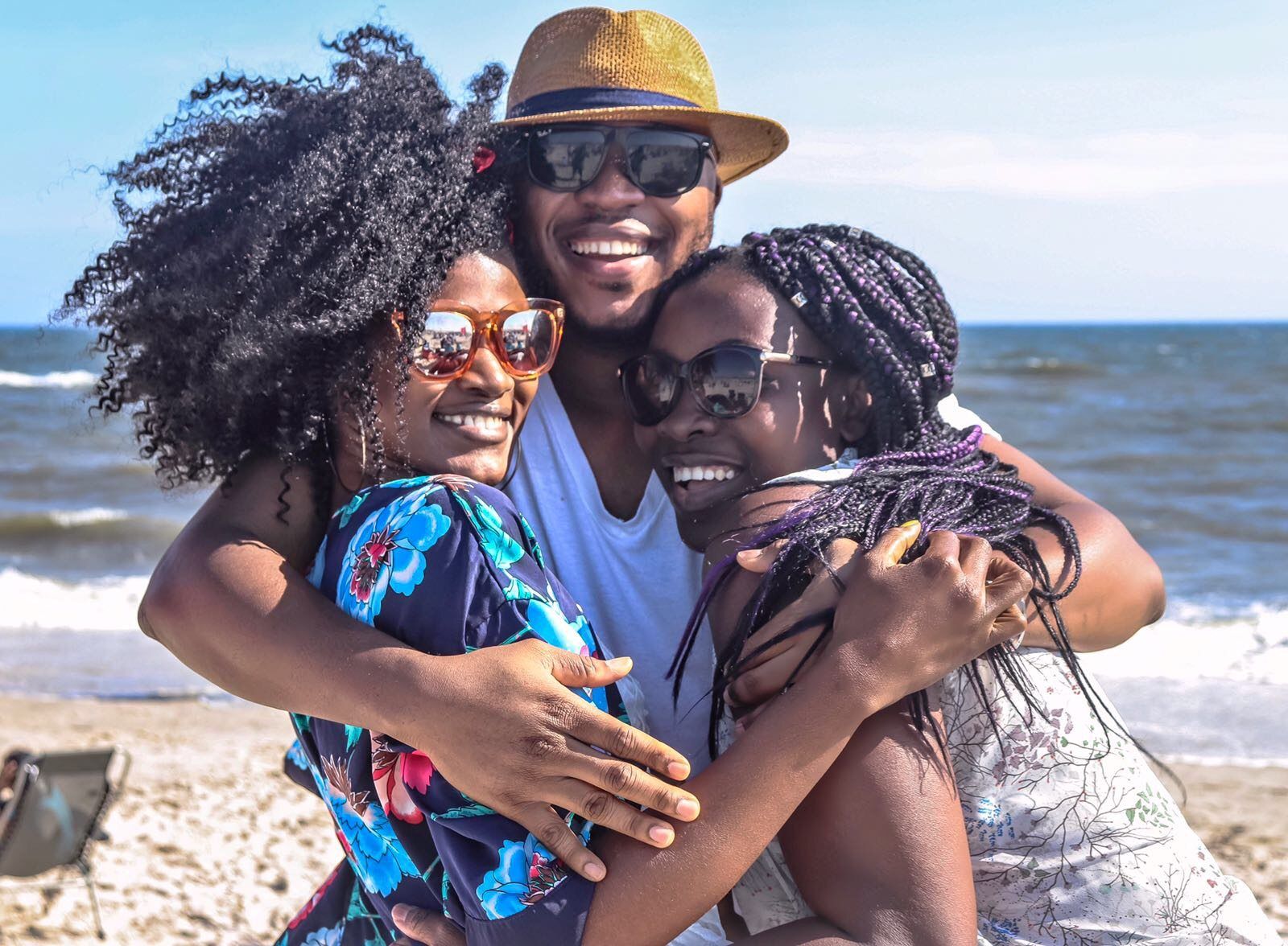 A group of people are hugging each other on the beach.