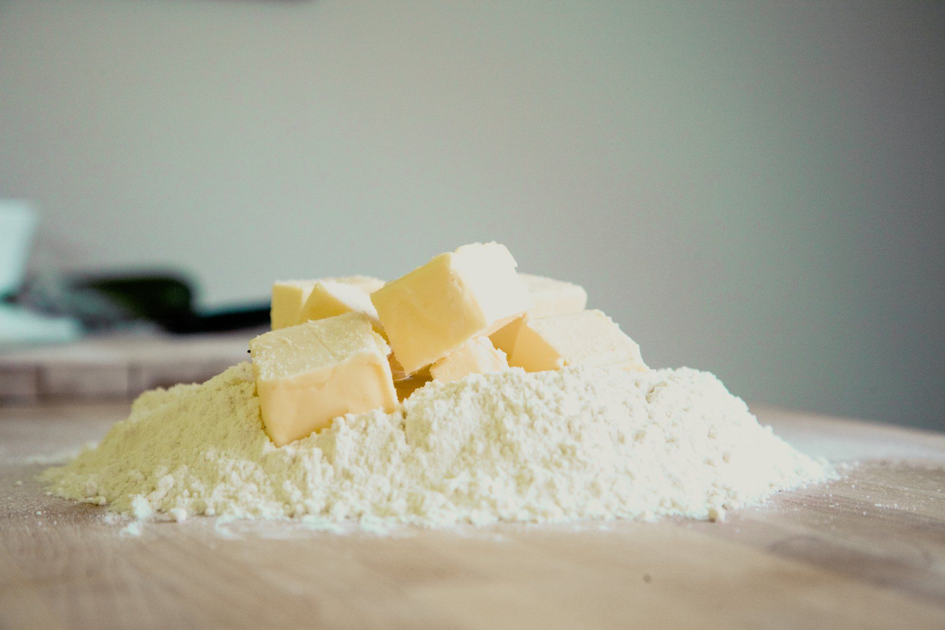 Flour and cubed butter on a wooden surface, ingredients for baking.