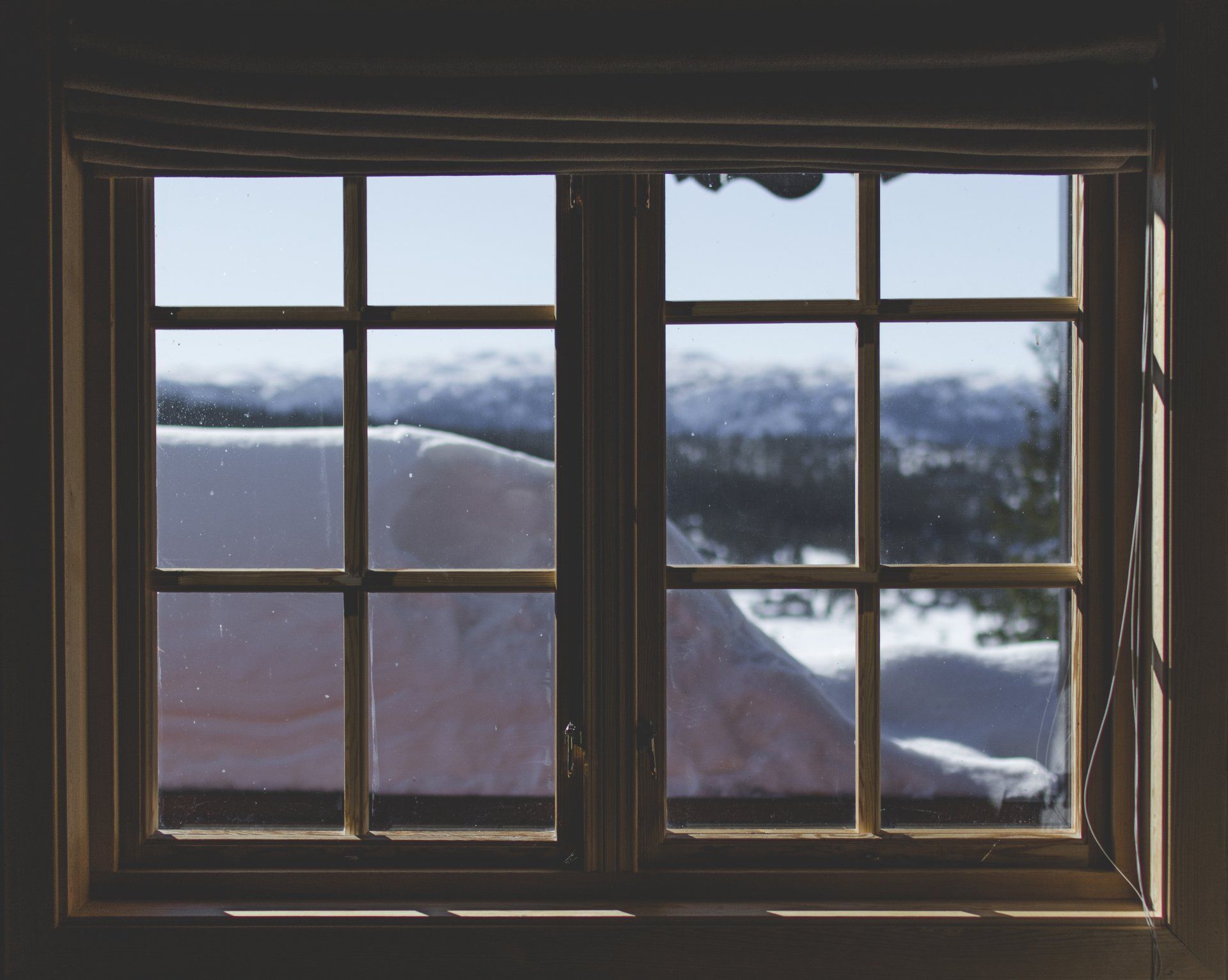 A window with a view of a snowy mountain range