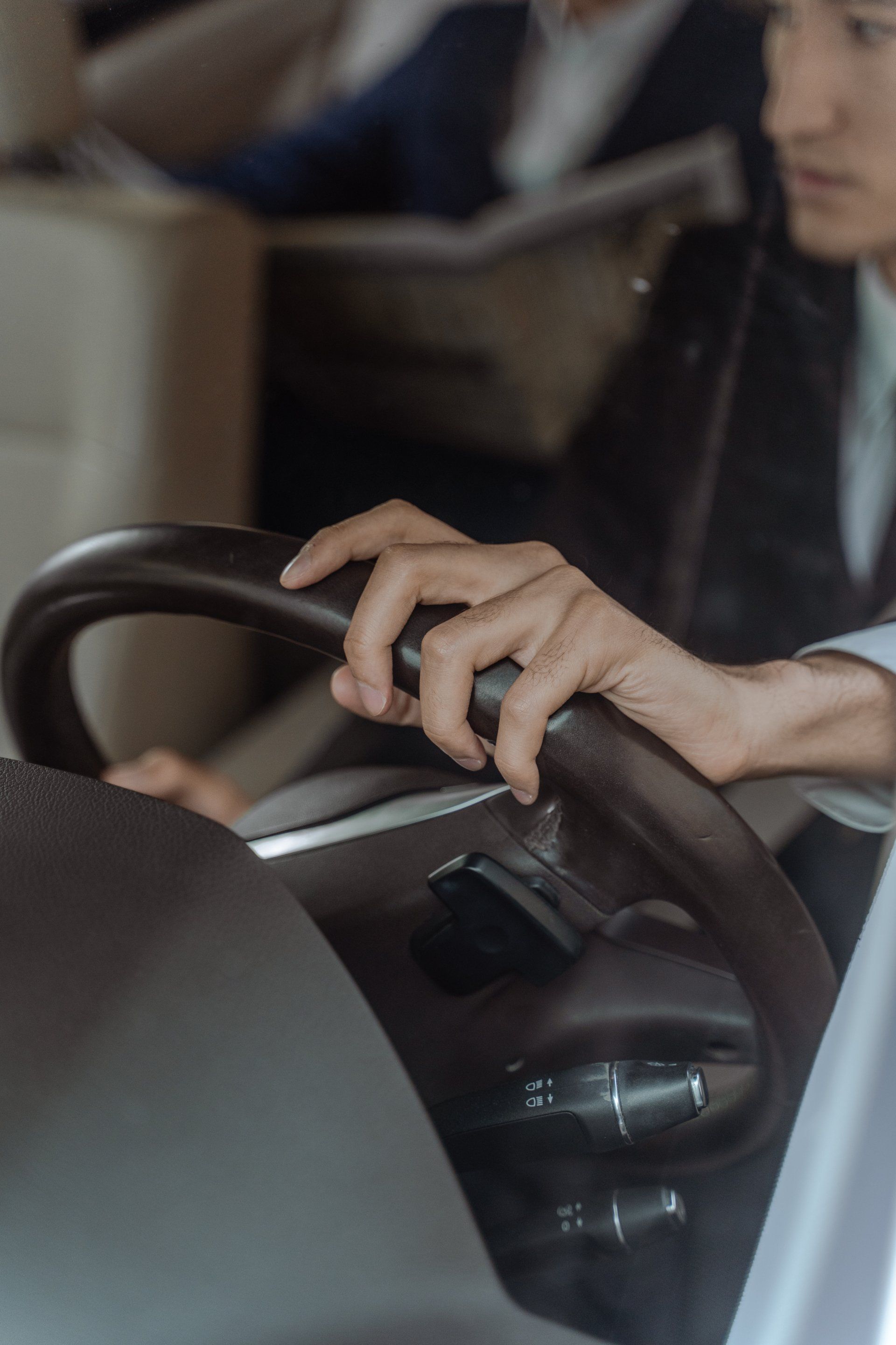 A person is holding the steering wheel of a car.