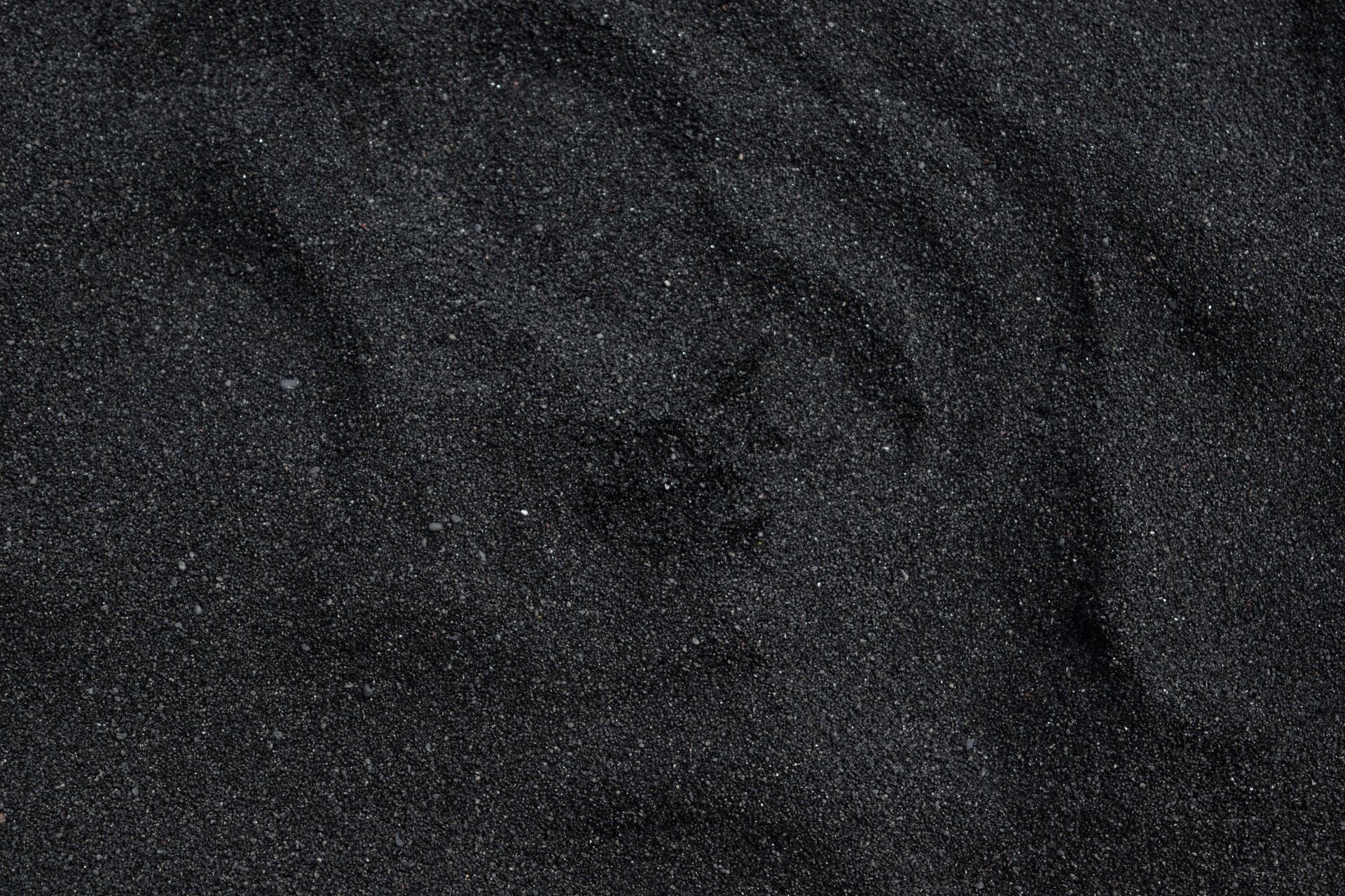 A close up of a pile of black sand.