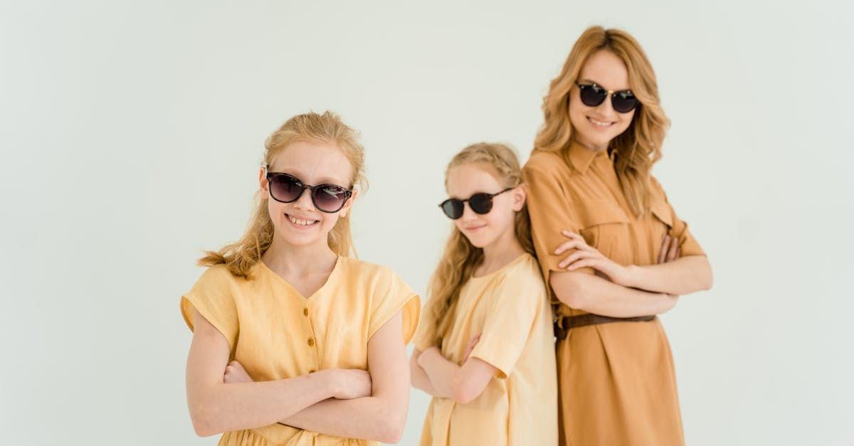 A woman and two girls wearing sunglasses are standing next to each other.