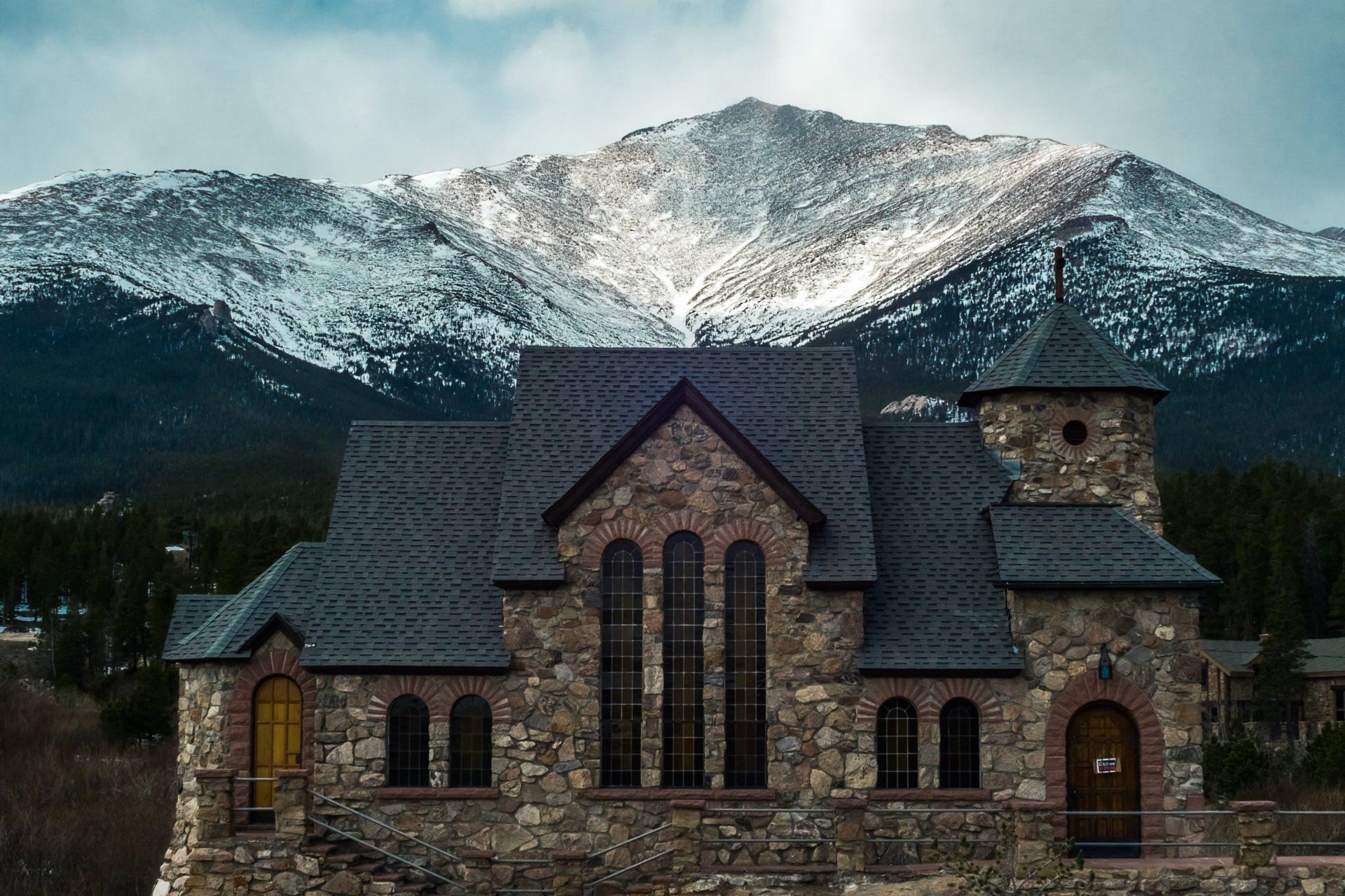 A stone church with a snowy mountain in the background