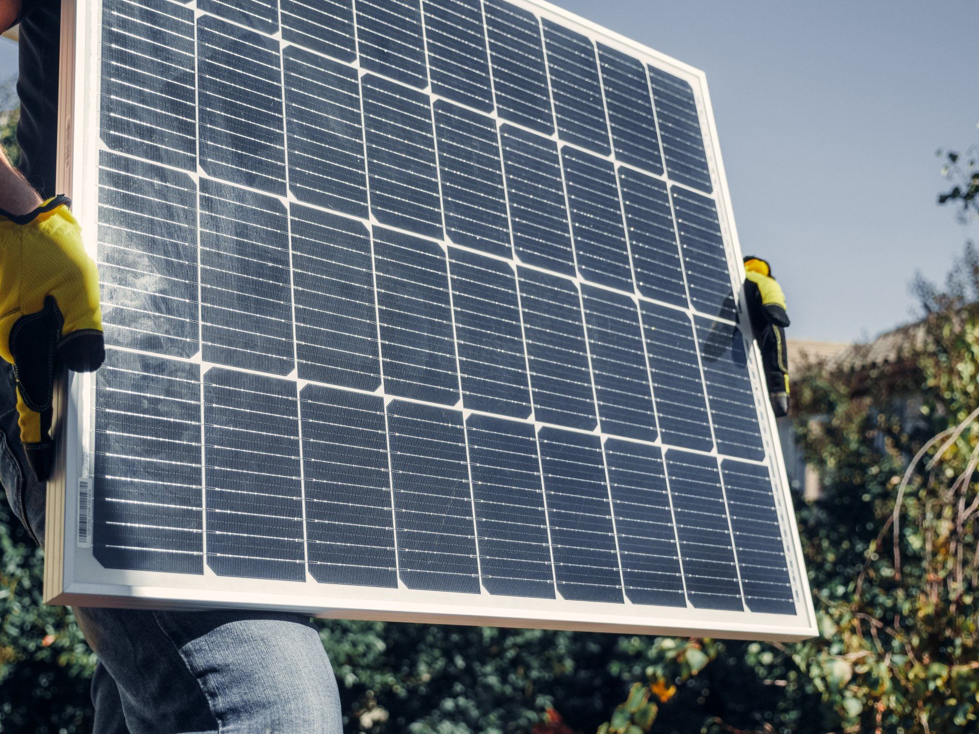 Eine Person hält ein Solarpanel in den Händen.