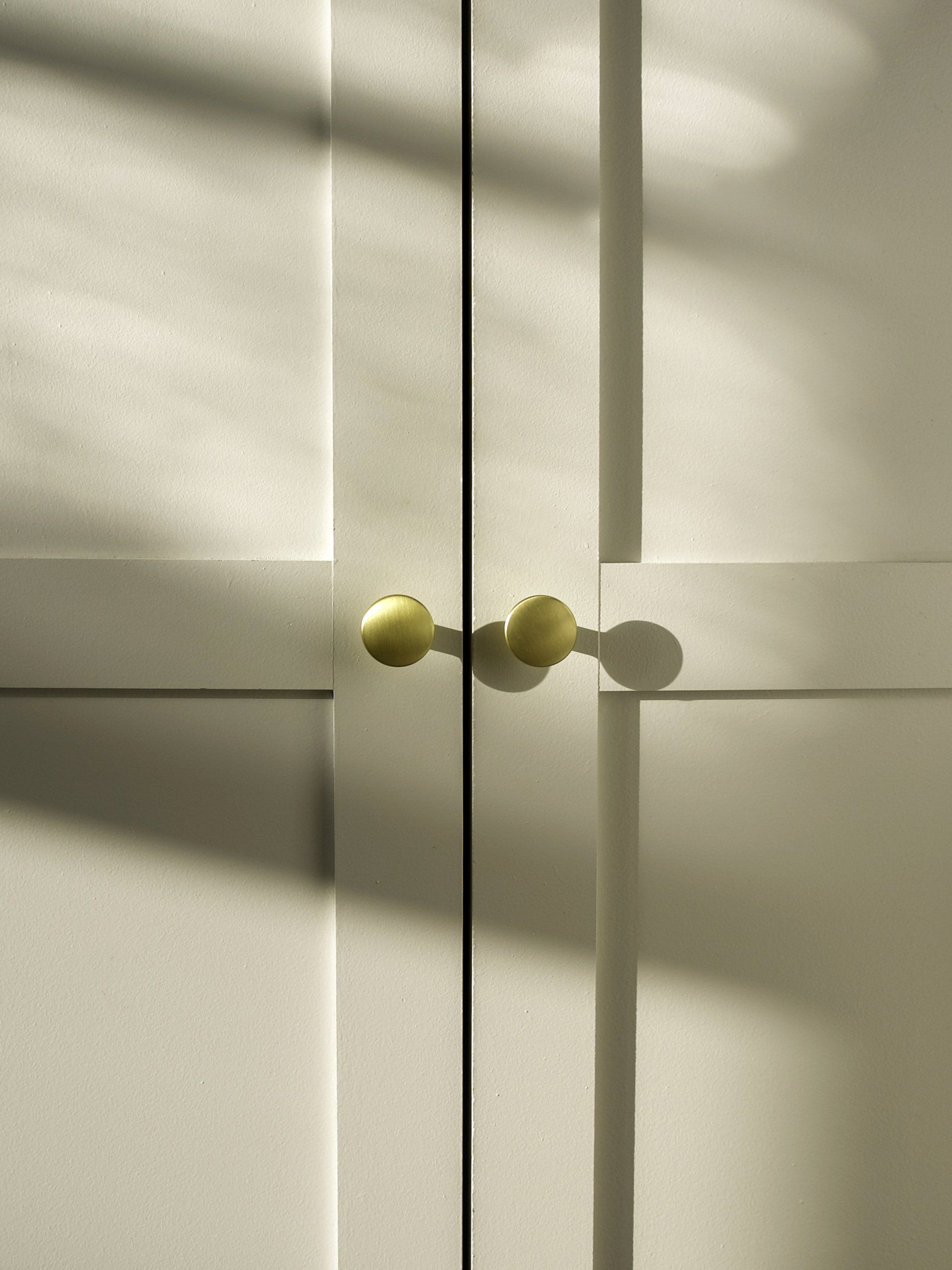 White cabinet doors with gold knobs.