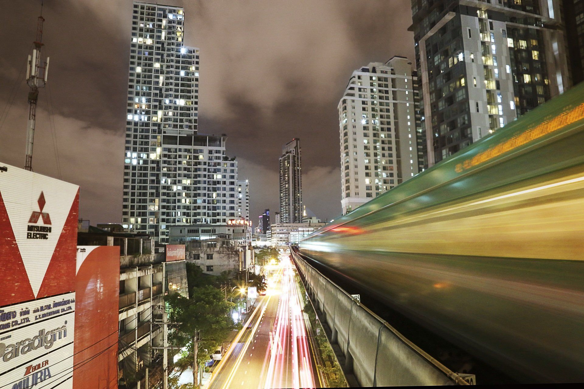 A train is going down a track in a city at night