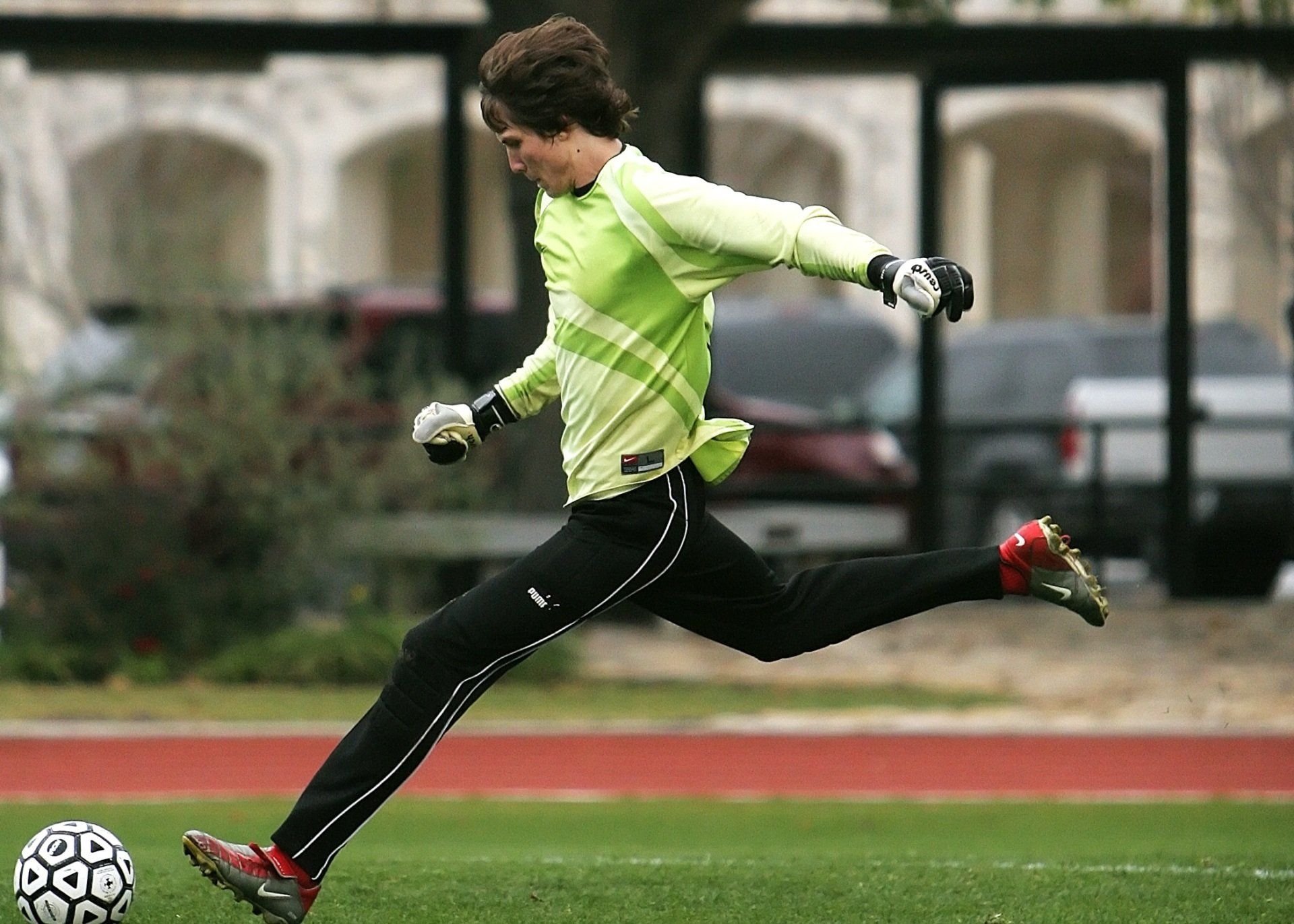 Um goleiro está chutando uma bola de futebol em um campo